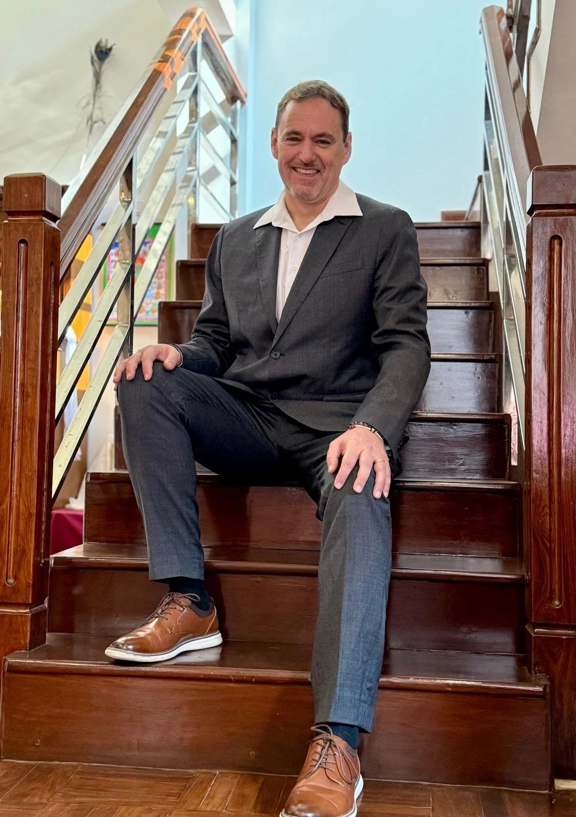 Professional headshot of prescriber A. Michael Crook sitting on stairs smiling.