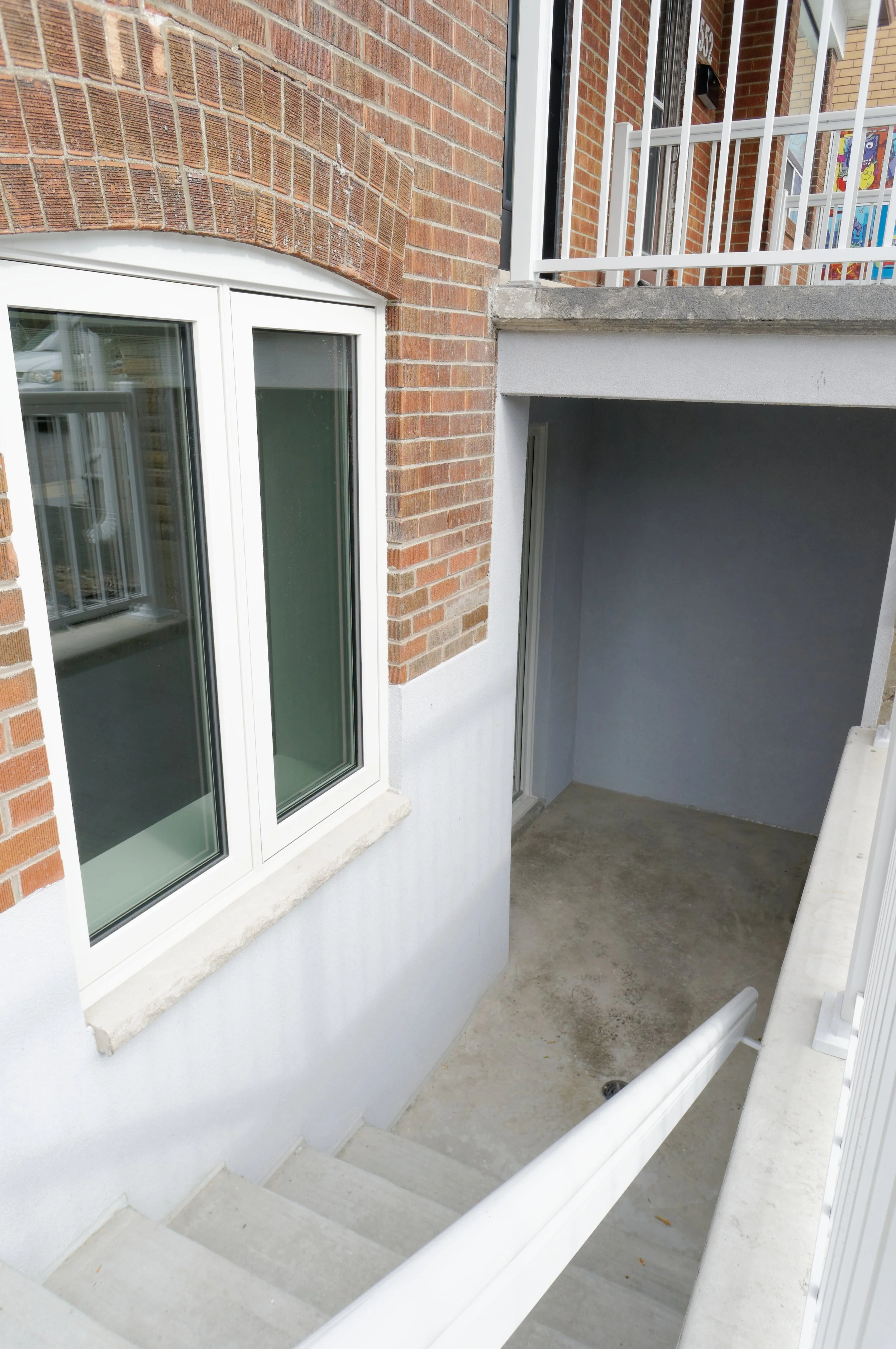 Exterior view of a multi-story residential building showing a staircase and a small outdoor balcony area.