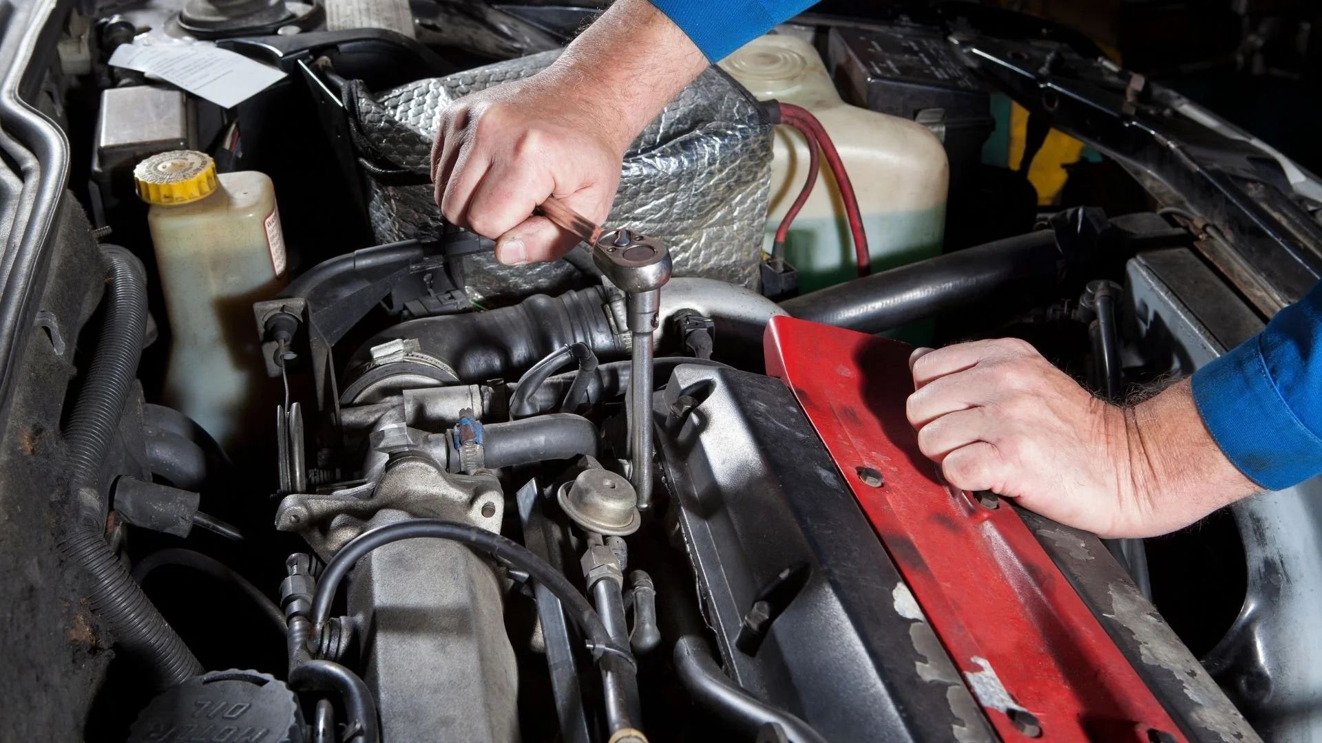 Automotive repair technician working on a vehicle engine at Jack’s Brake & Alignment in Davenport Iowa