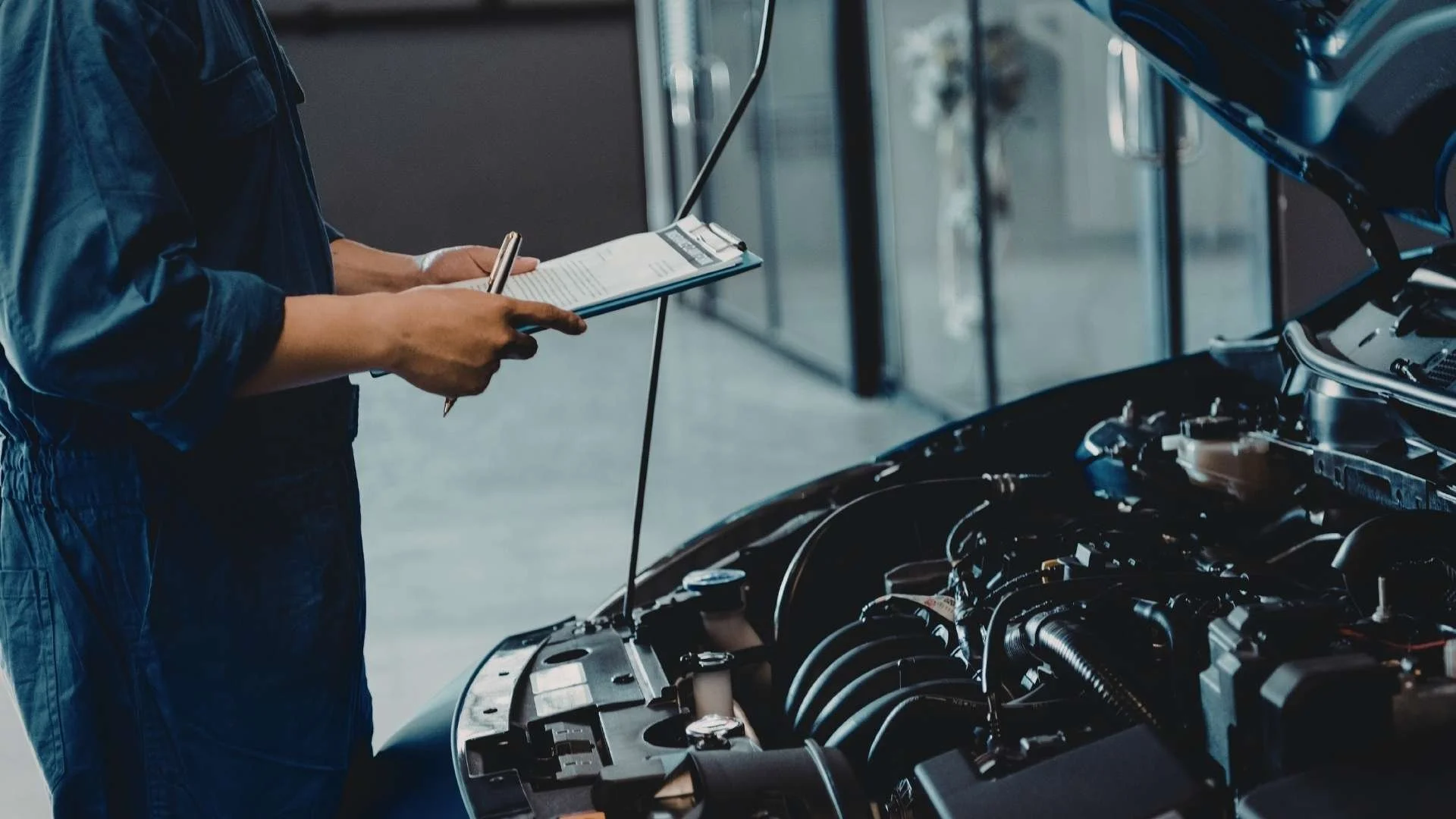 Auto technician inspecting engine during vehicle service at Jack’s Brake & Alignment in Davenport Iowa