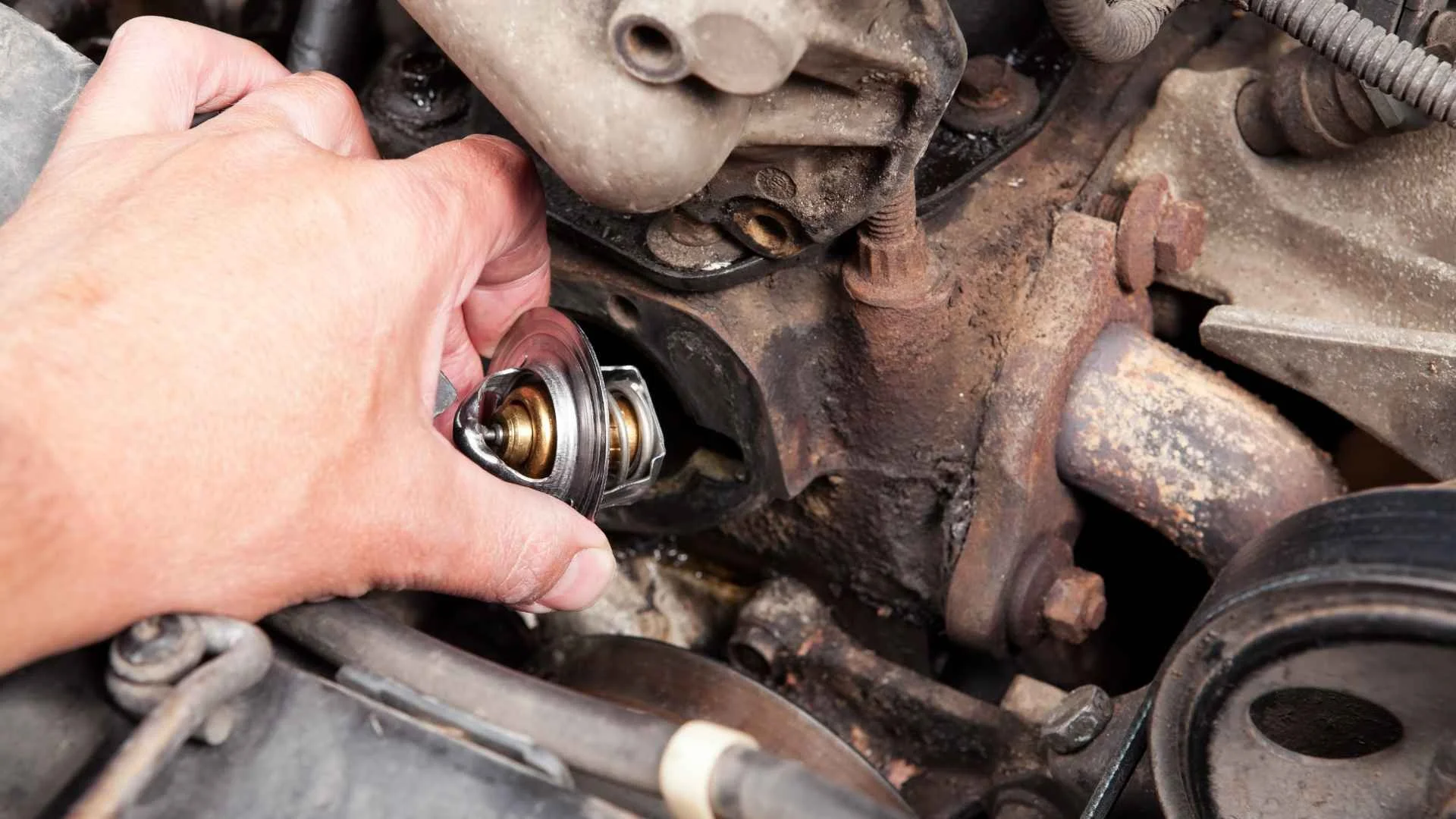 A person using a wrench to remove or install a car radiator cap from an engine.