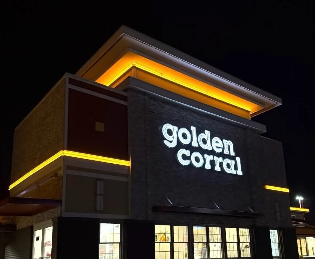 Golden Corral storefront at night with illuminated white lettering and yellow facade lighting.