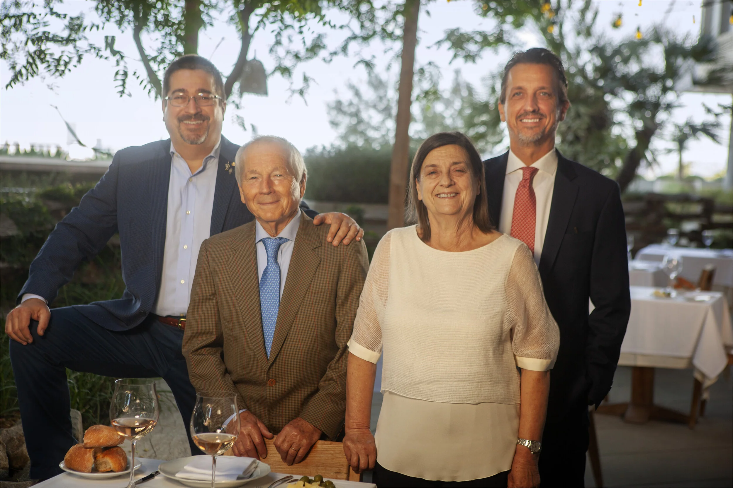 Family photo of Alfio, his wife Elvira, and sons Gianni and Nicola standing at a table.