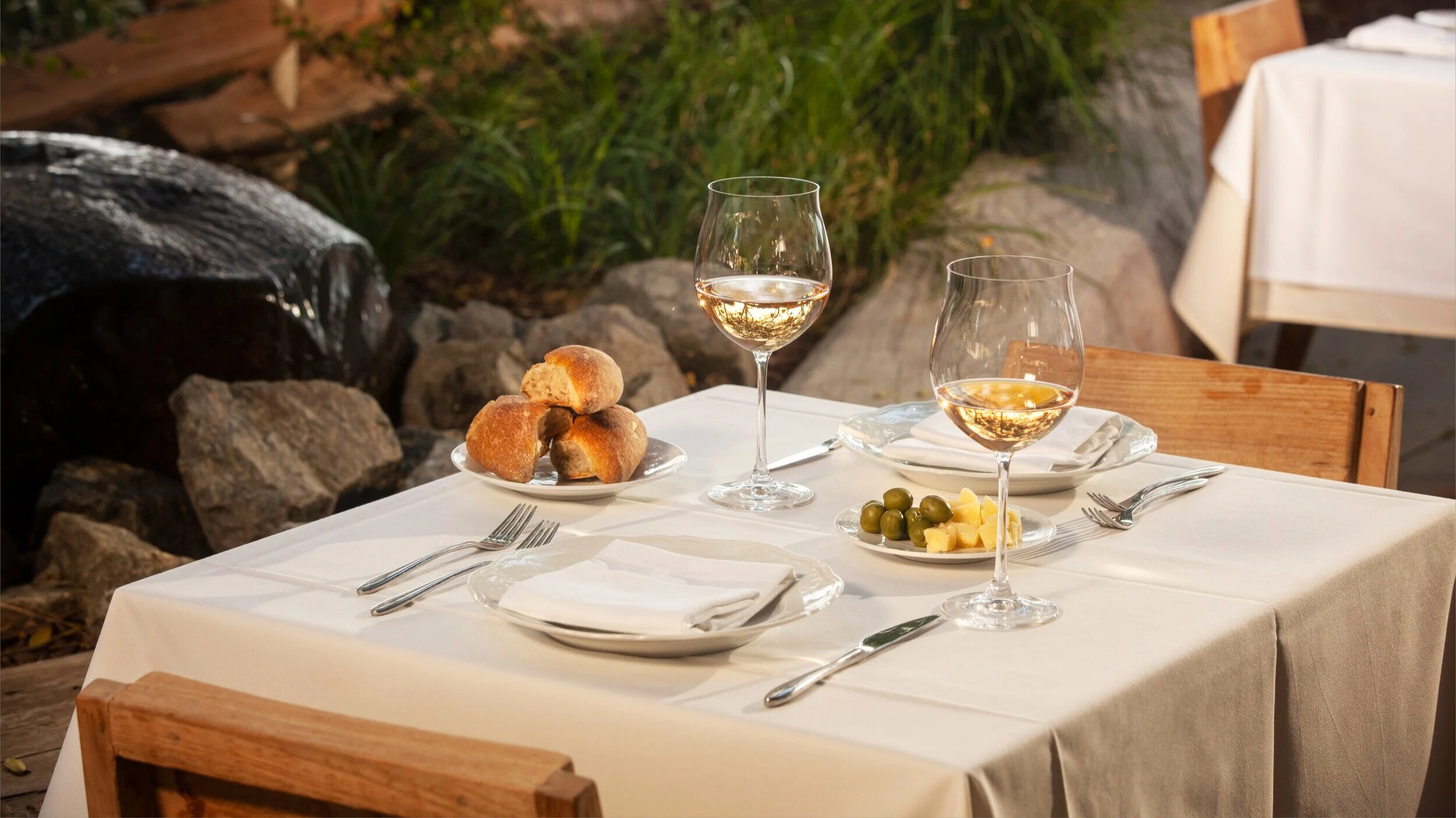 Photo of outdoor table scape with appetizers and wine.