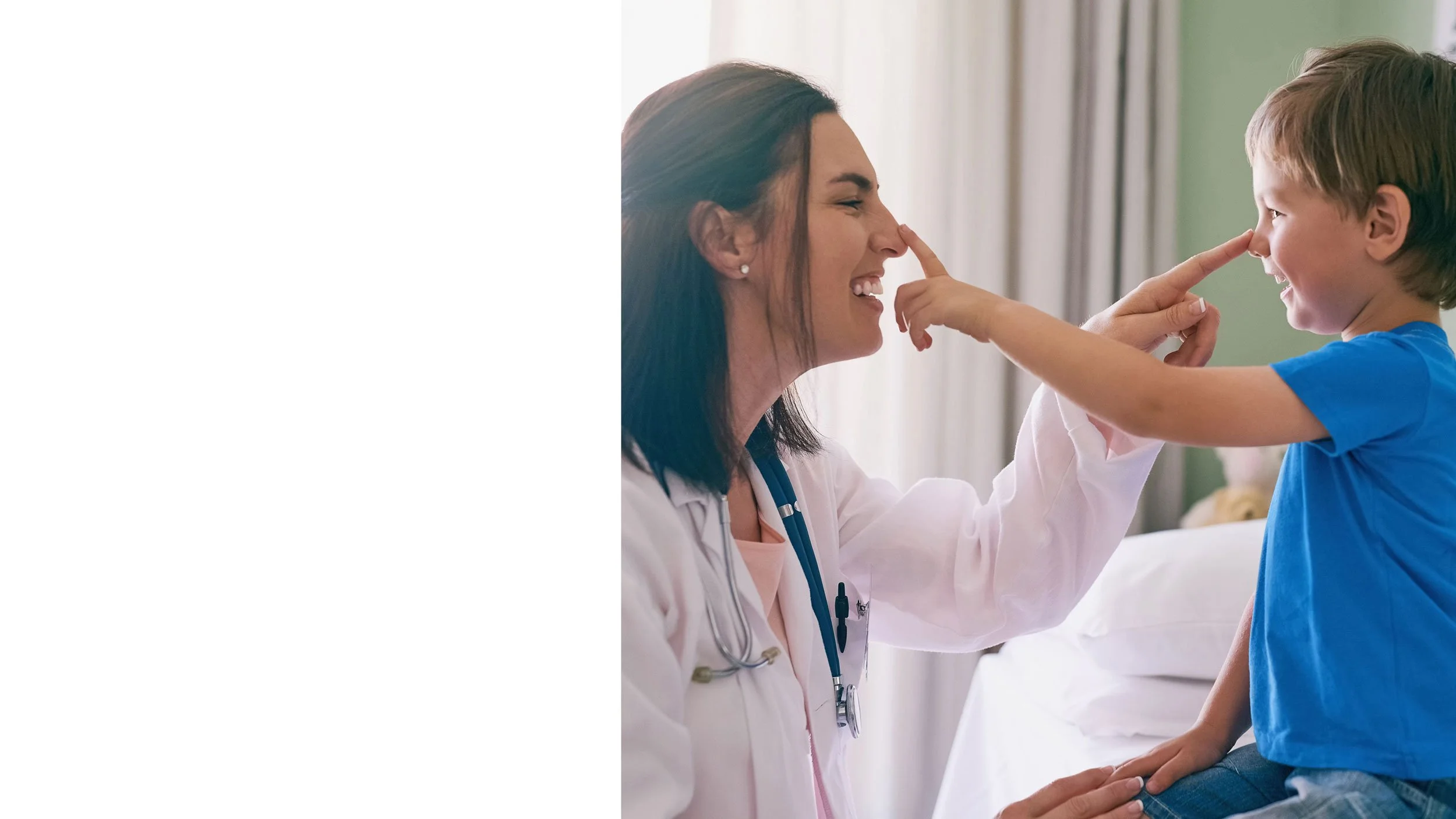 Pediatrician examining a young child's heart with a stethoscope as the caregiver holds the child.