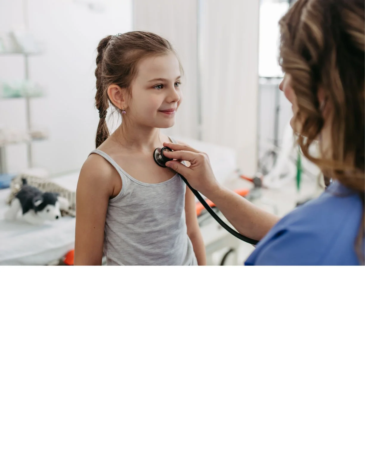 Doctor using a stethoscope on young girl in a clinical setting.