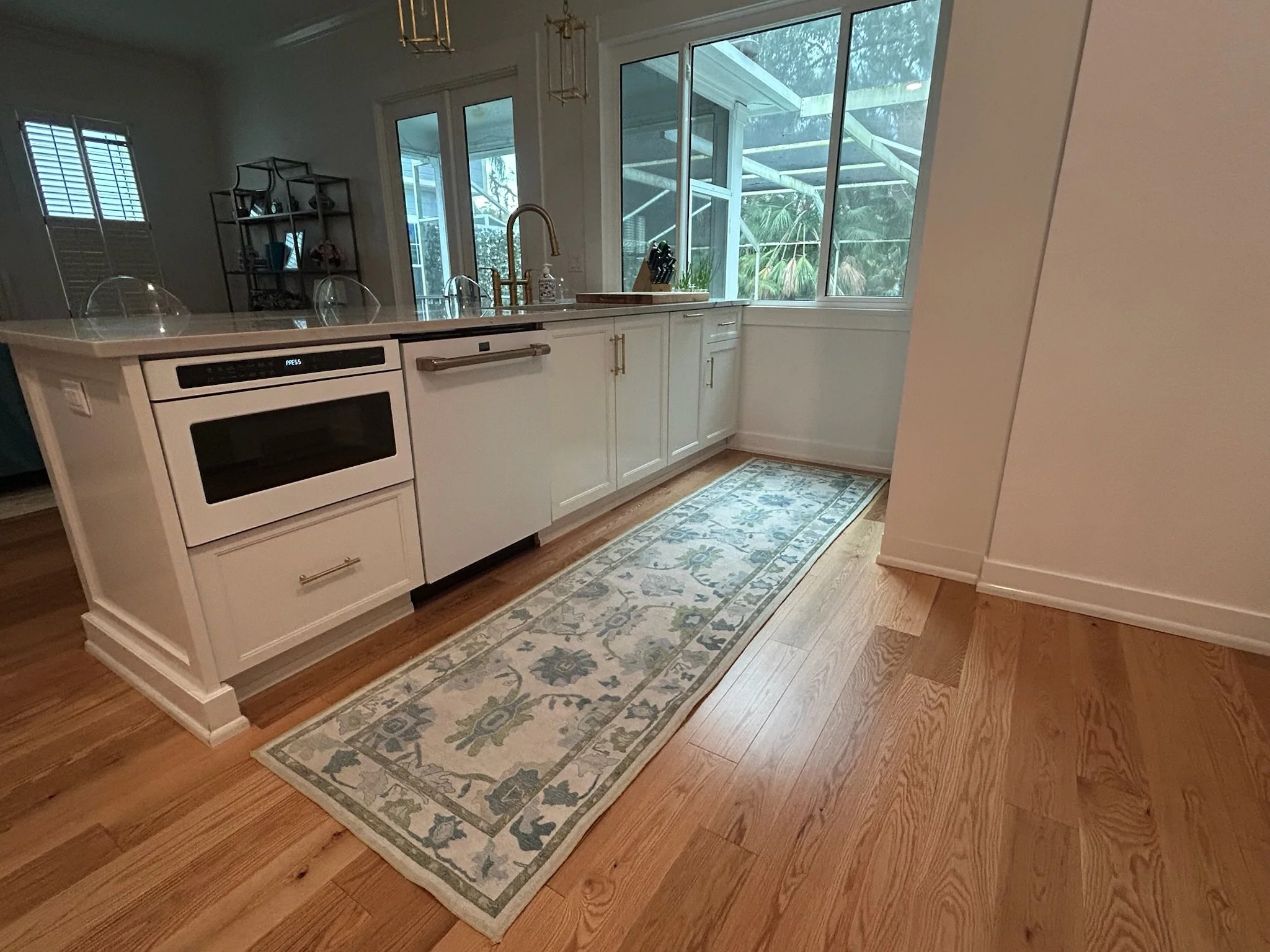 A kitchen with white custom cabinets and shelves