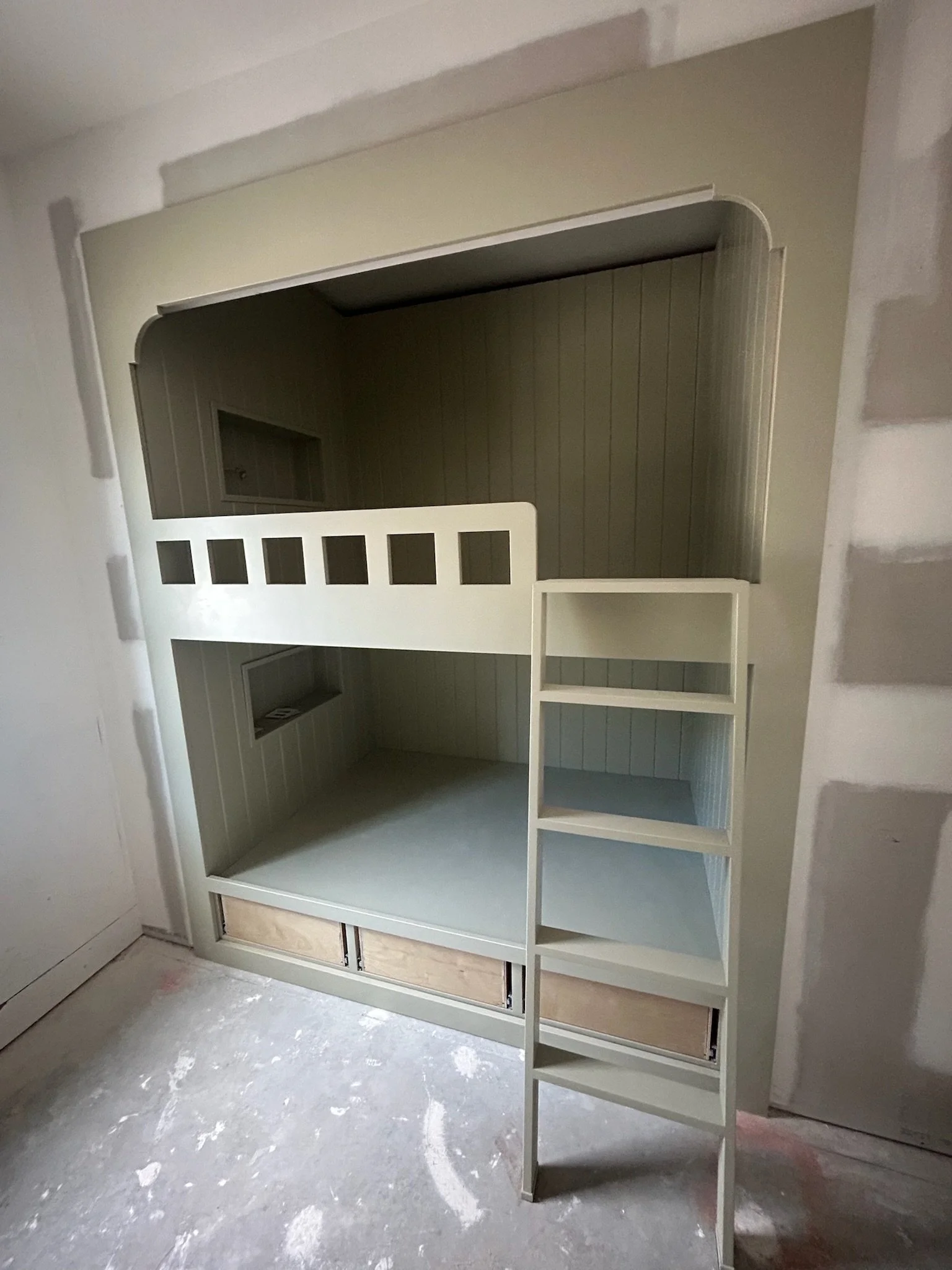 A custom-built bedroom bunk bed with a ladder