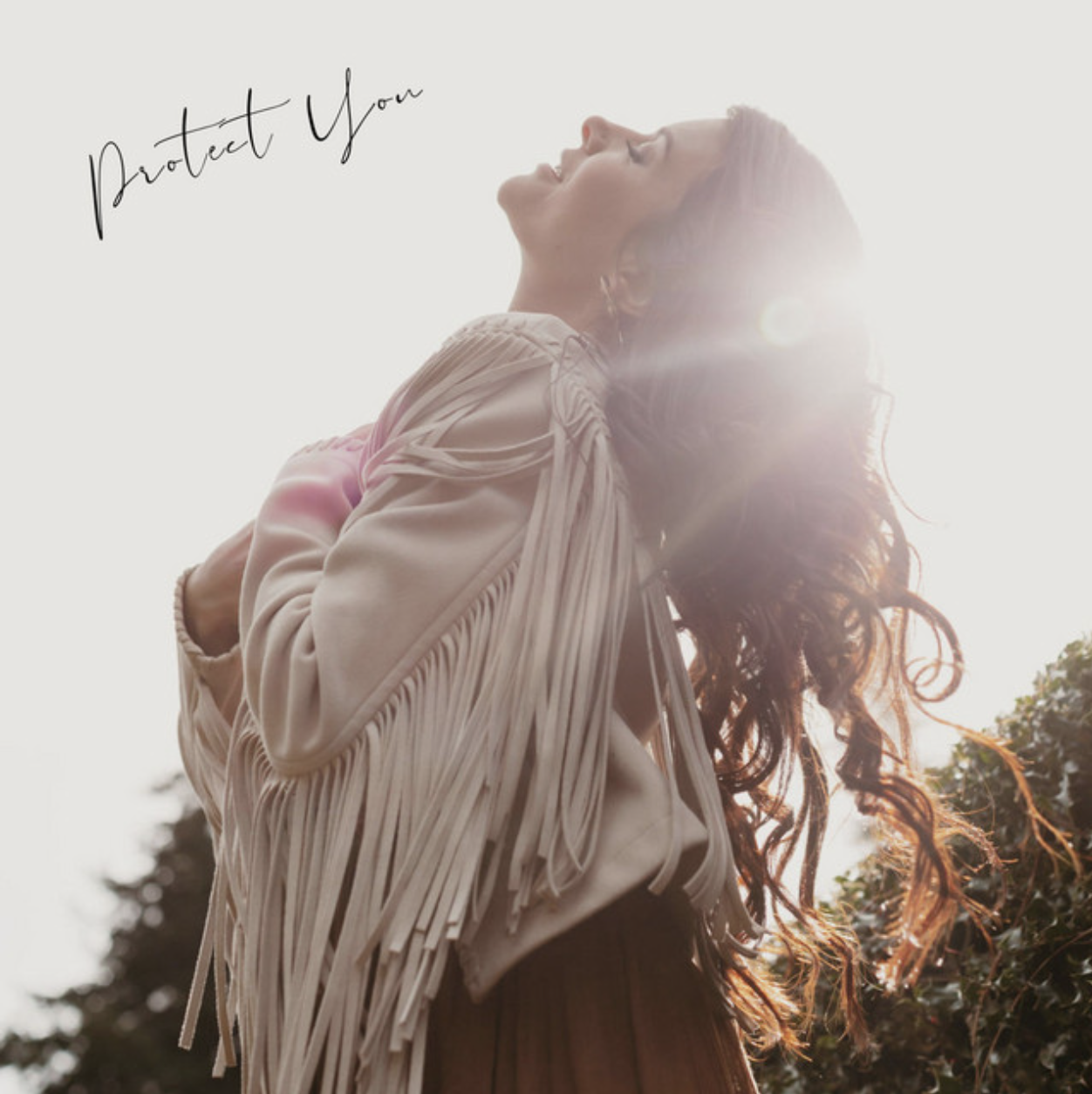 A woman with long, wavy hair and a fringed jacket stands outdoors with her face tilted upward, backlit by sunlight, with the words "Protect You" written in cursive in the top left corner.