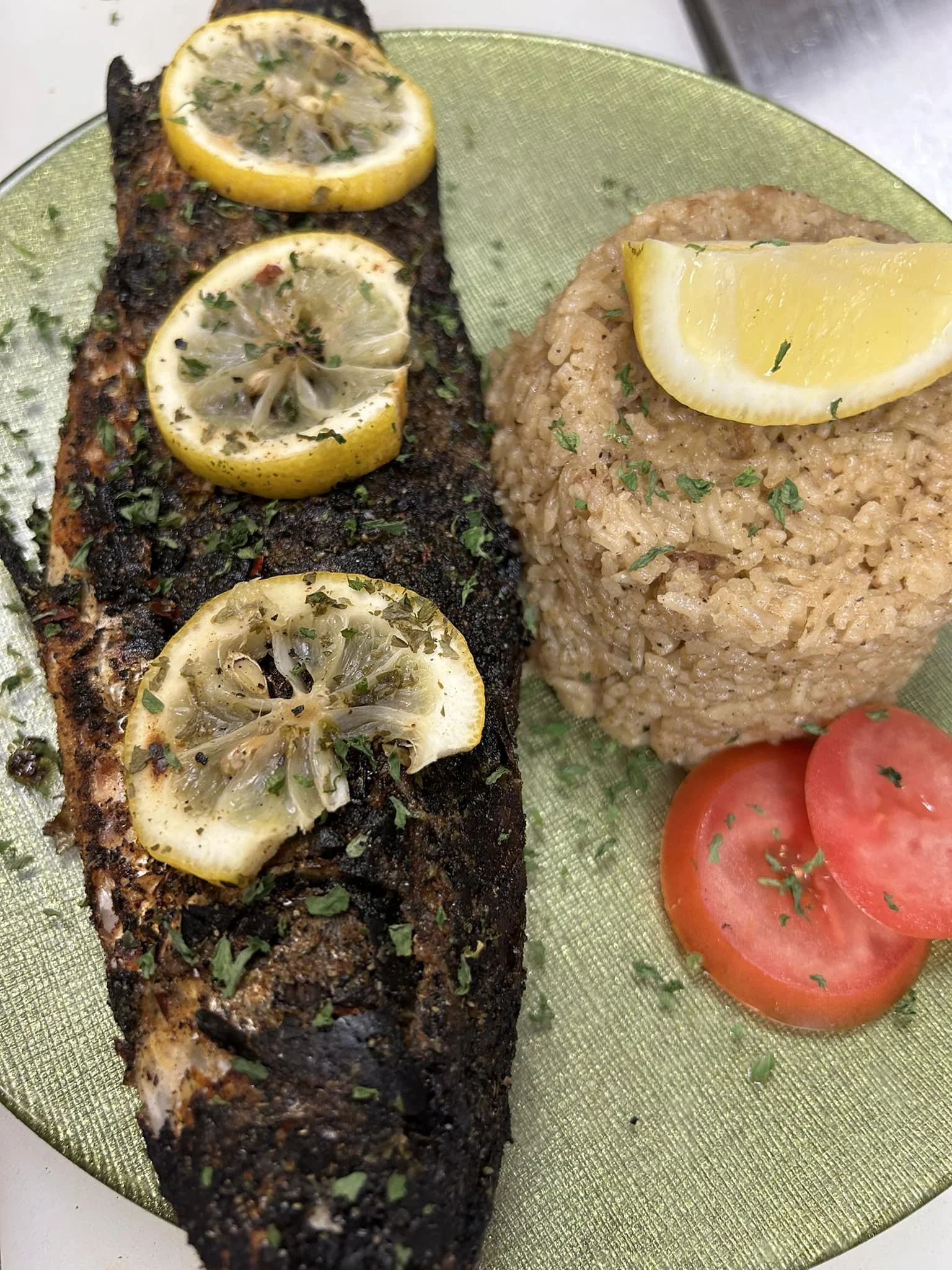 Blackened grilled fish with seasoned rice, lemon, and tomato from West Fortune Fish Market