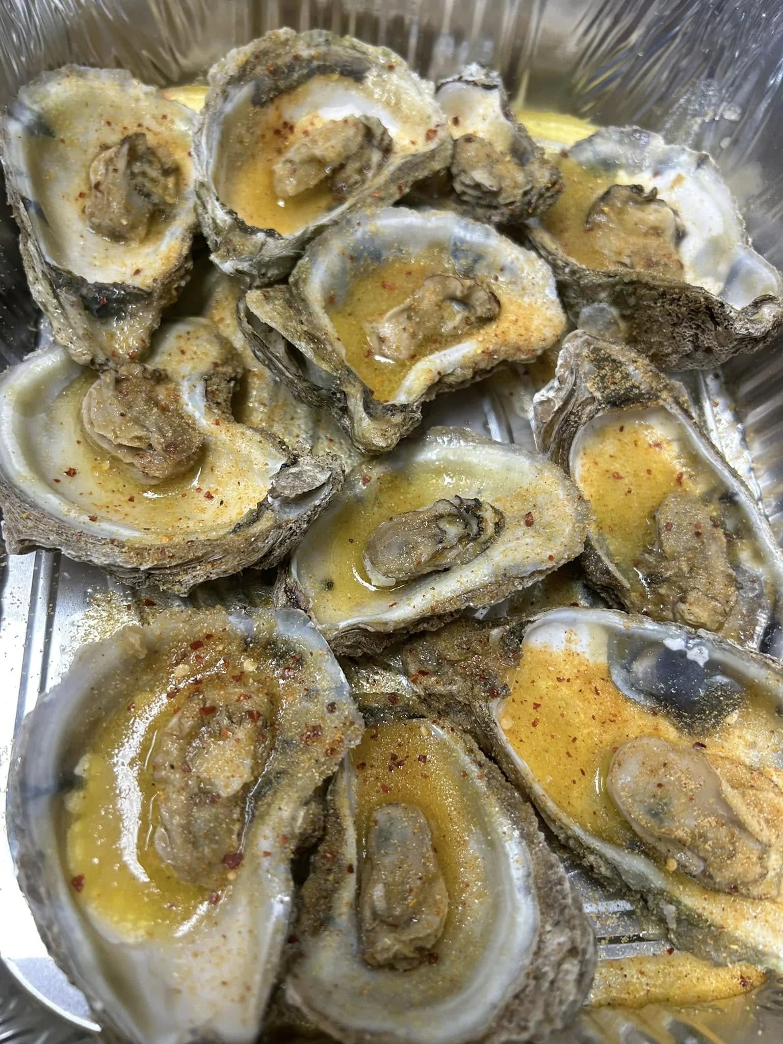 Oysters topped with garlic butter and Cajun seasoning served hot in Tampa seafood tray