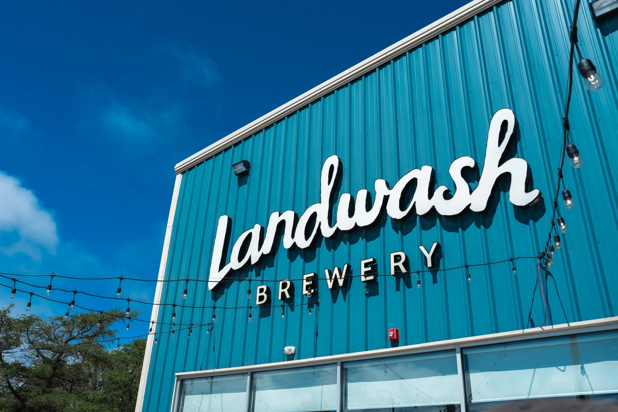 The exterior of Landwash Brewery under a bright blue sky.