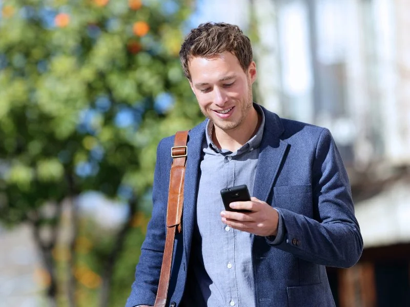 Business owner checking his phone during summer break causing cyber security breach