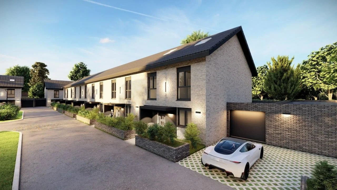 Modern townhouse complex with a white brick exterior, black roof, and front porches. A white sports car is parked in front of a gated garage. The area features landscaped greenery and paved parking.