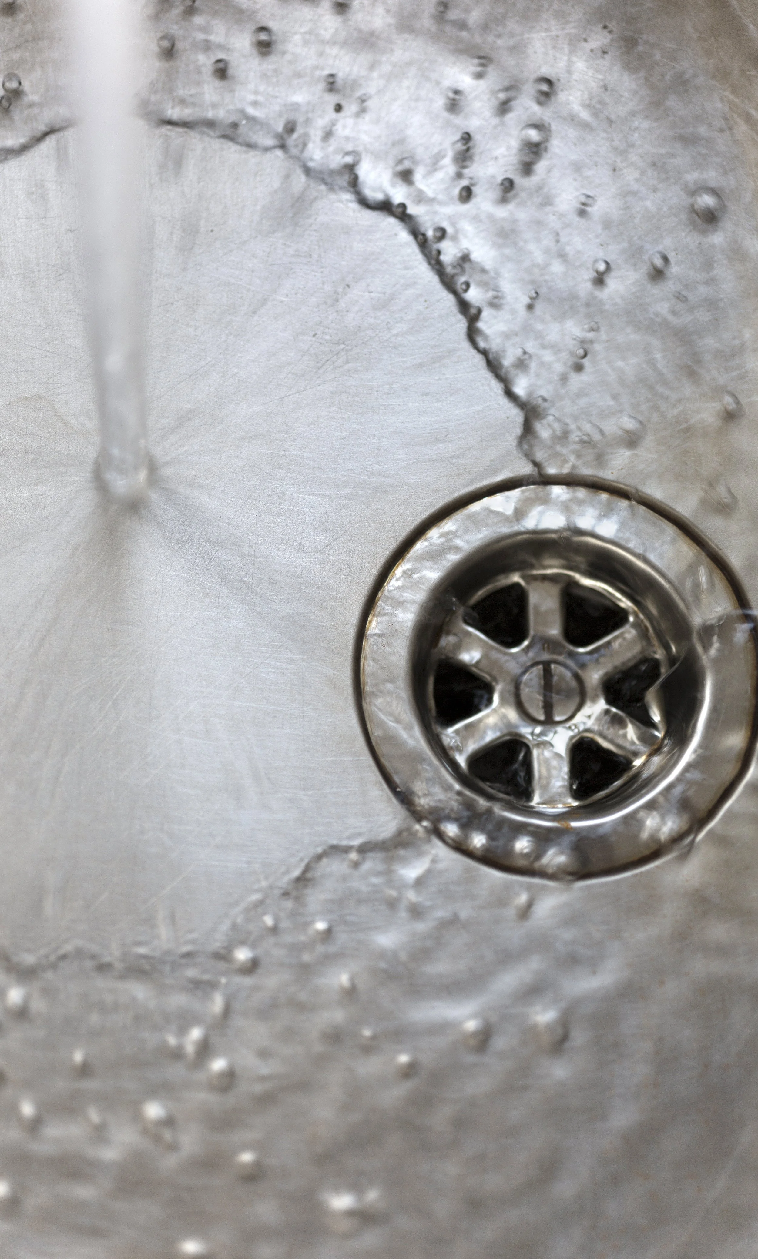 Clean stainless steel sink with water draining clearly