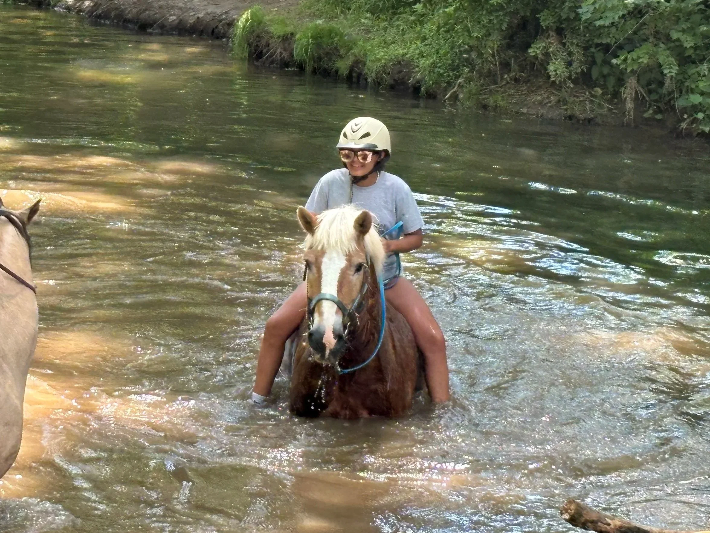 Girl riding bareback in river