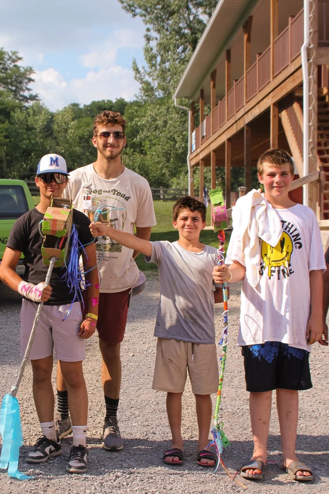 boys holding cardboard stick horse