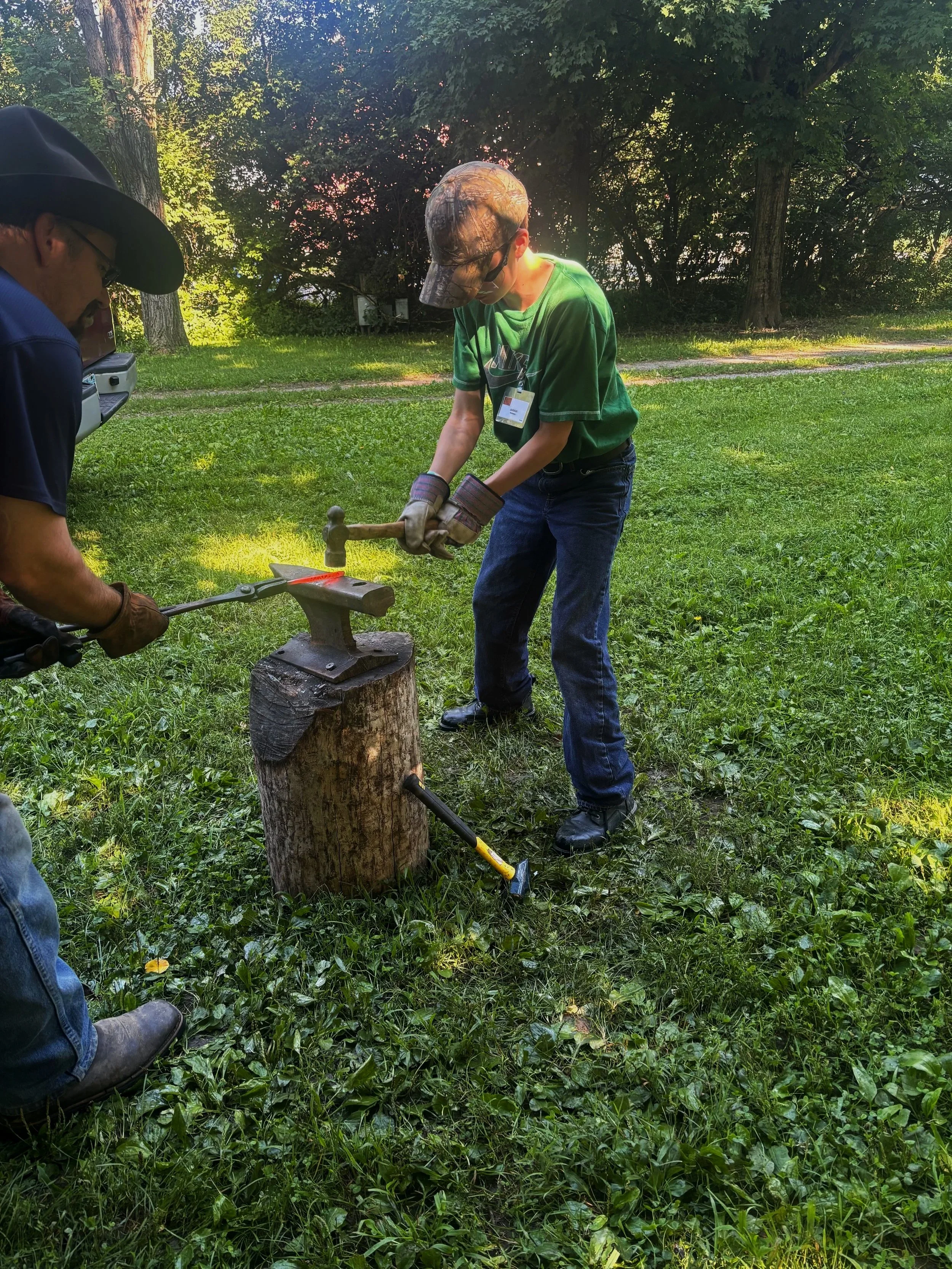 camper learning blacksmithing