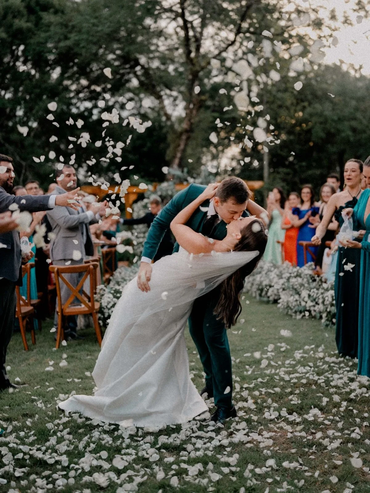 No fim da cerim&ocirc;nia,
o beijo n&atilde;o &eacute; s&oacute; beijo.
&Eacute; promessa com forma,
sil&ecirc;ncio com sentido,
amor dizendo
&ldquo;agora, diante do mundo, somos n&oacute;s&rdquo;.

E quando as p&eacute;talas brancas caem,
n&atilde;o