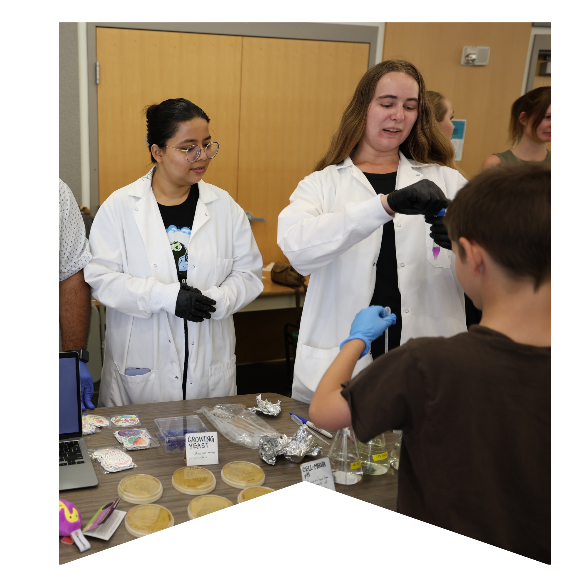 Two female scientists interacting with a child