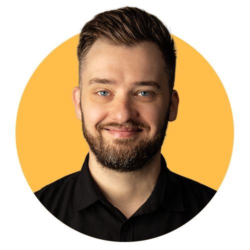 A portrait of a man with light brown hair, beard, and blue eyes, smiling, wearing a black shirt, with a yellow and black background.