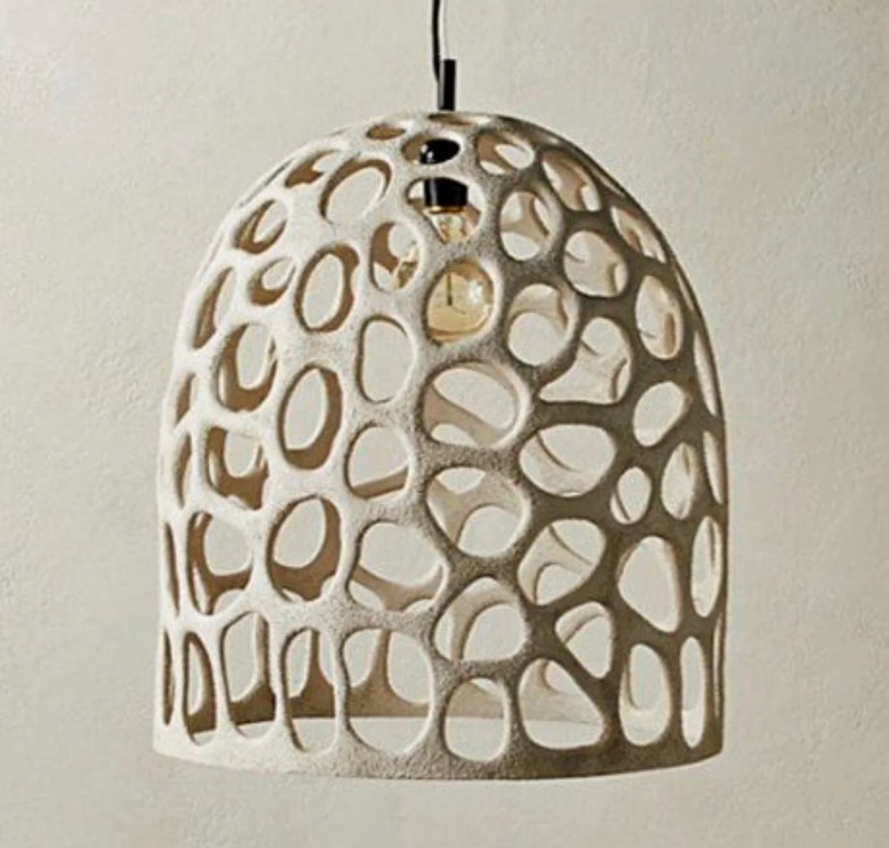 Decorative pendant light with a honeycomb pattern, hanging from the ceiling. Aluminum frame. White stucco. 