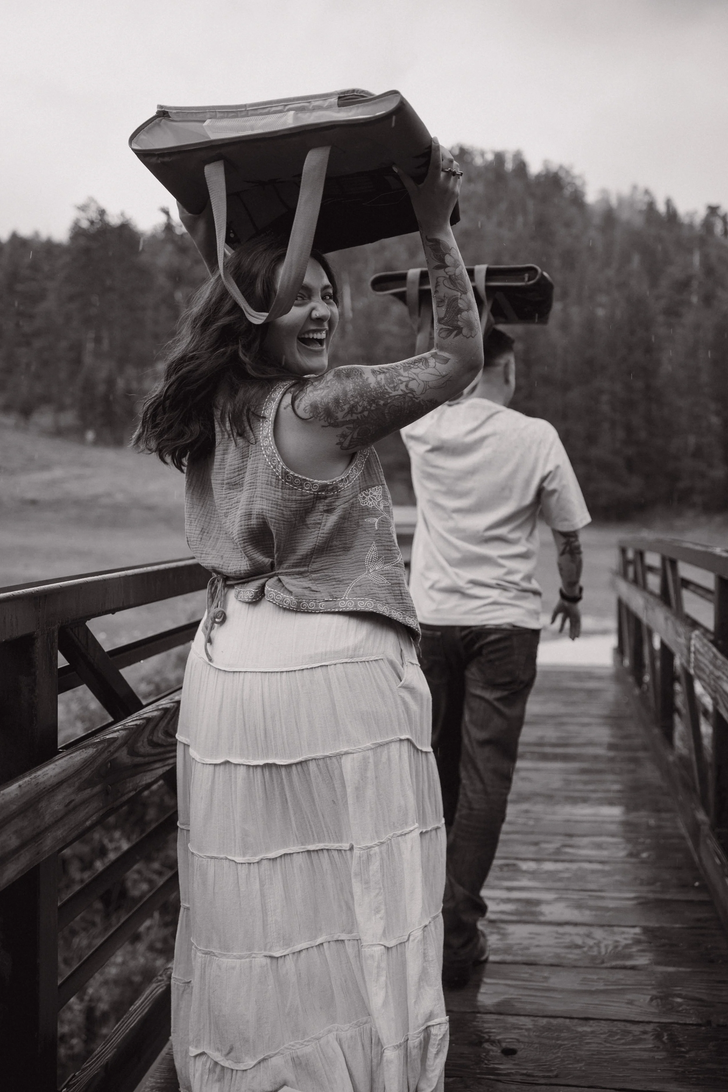 Couple walking down a bridge in the rain during a photoshoot