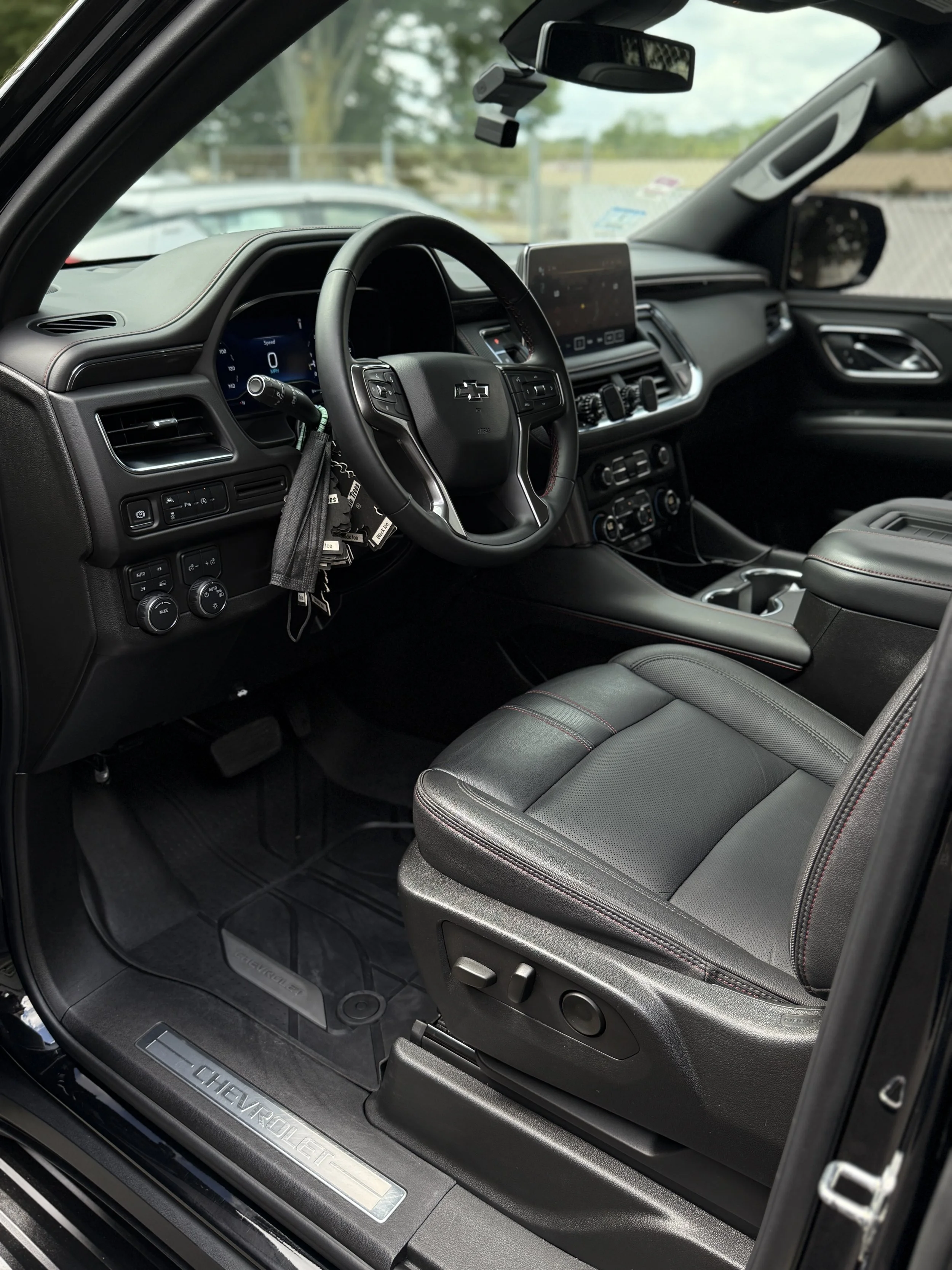 Interior of a Chevrolet vehicle showing the driver's seat, steering wheel, dashboard, and center console.