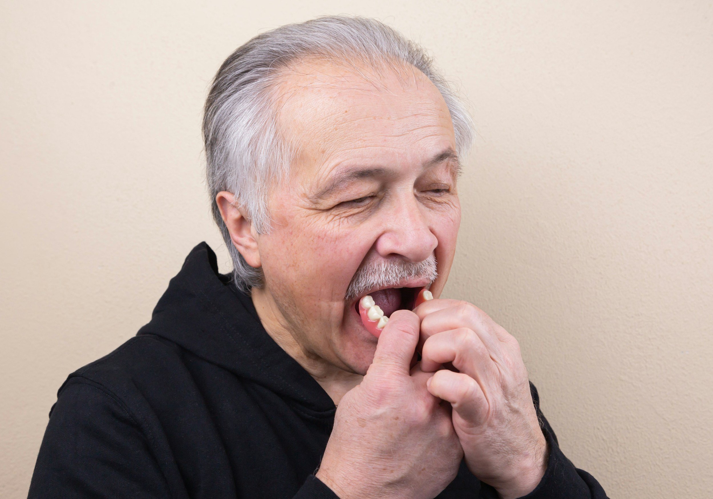 Patient placing implant-supported denture in Centralia WA – Twin City Smiles