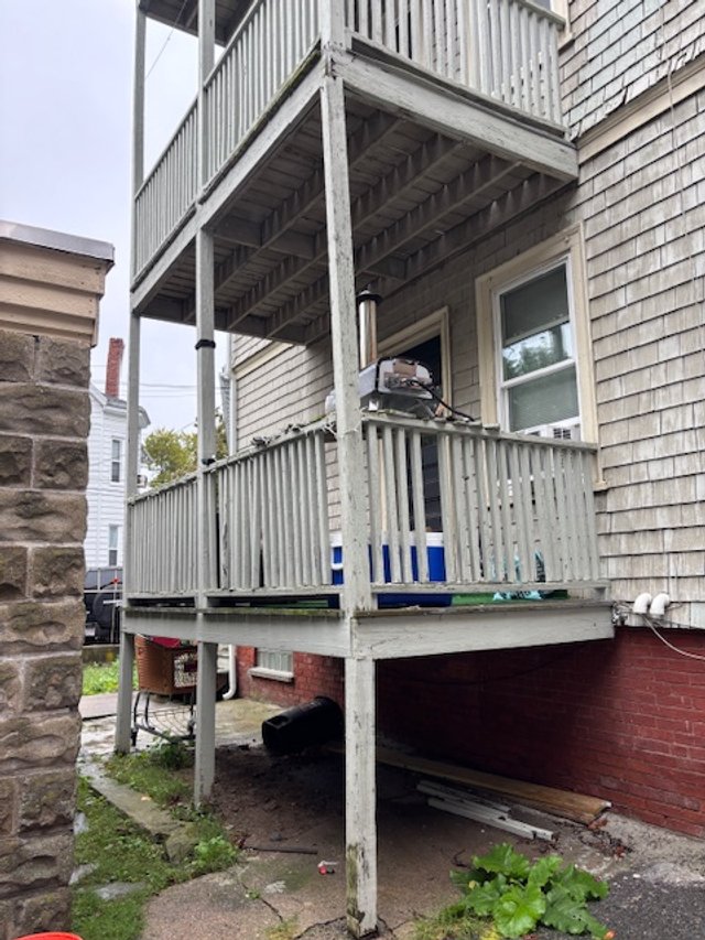 Distressed three-story rear porch in Somerville, MA before demolition