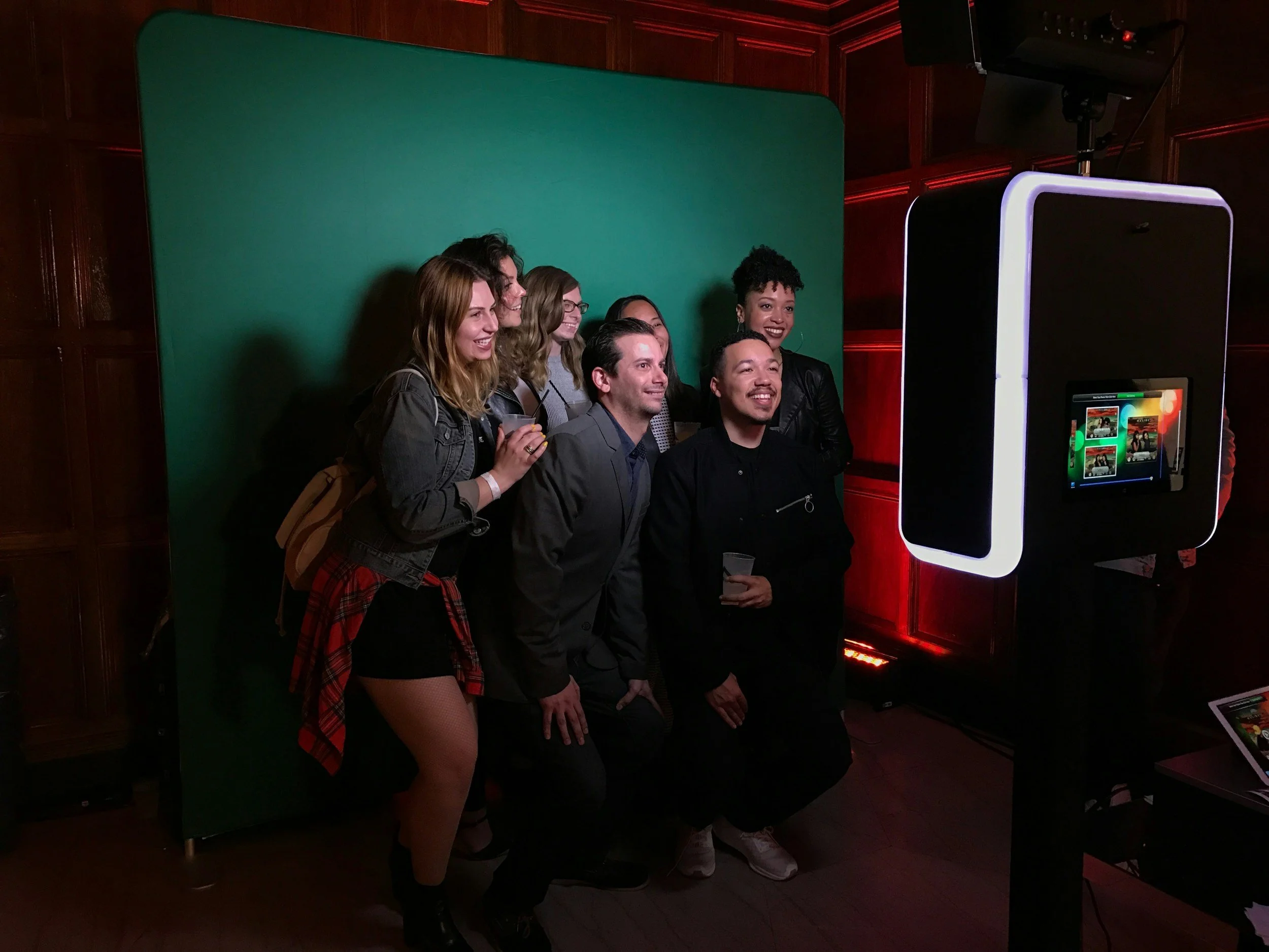 Group of people getting photos taken at photo booth.