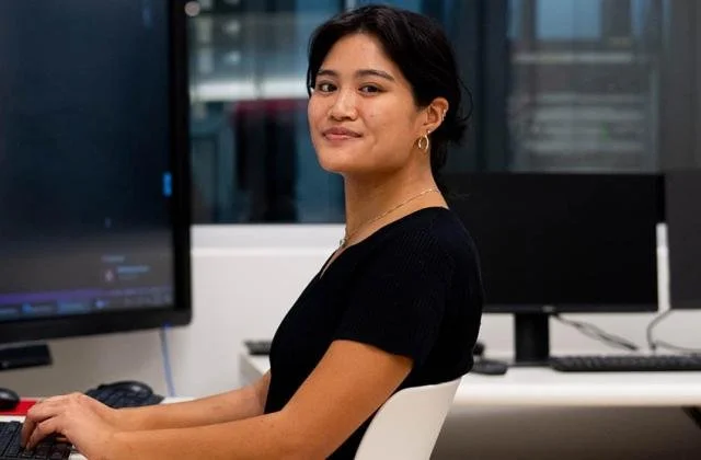 Smiling student at a desk in a computer lab