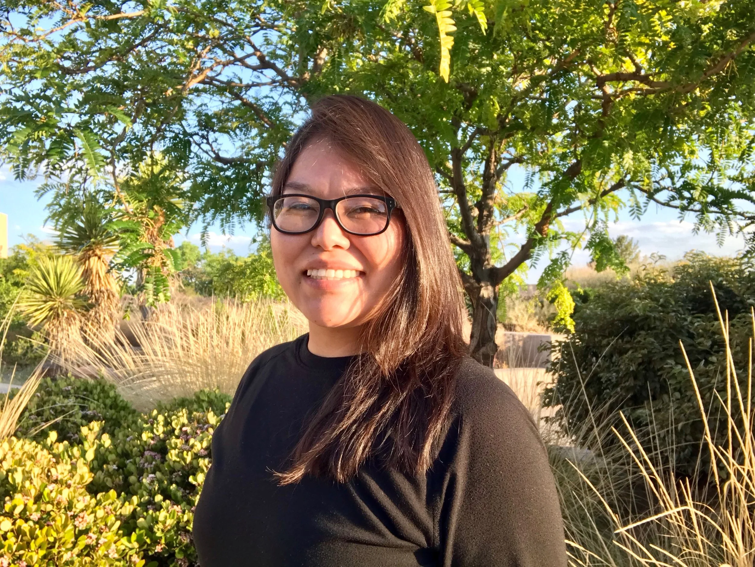 Last Mile awardee Tamara F. smiling outdoors under trees