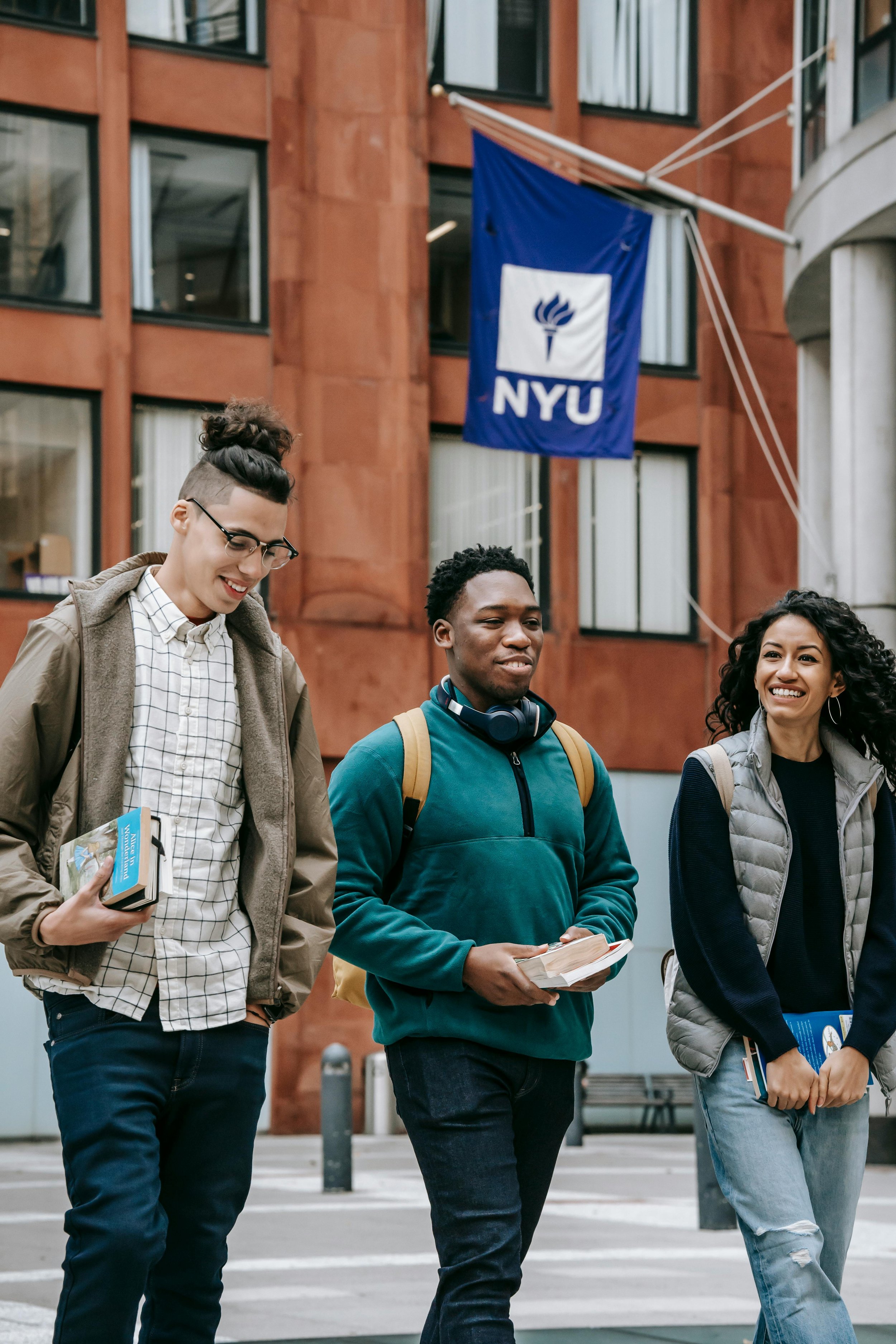 Students walking past an NYU flag on campus