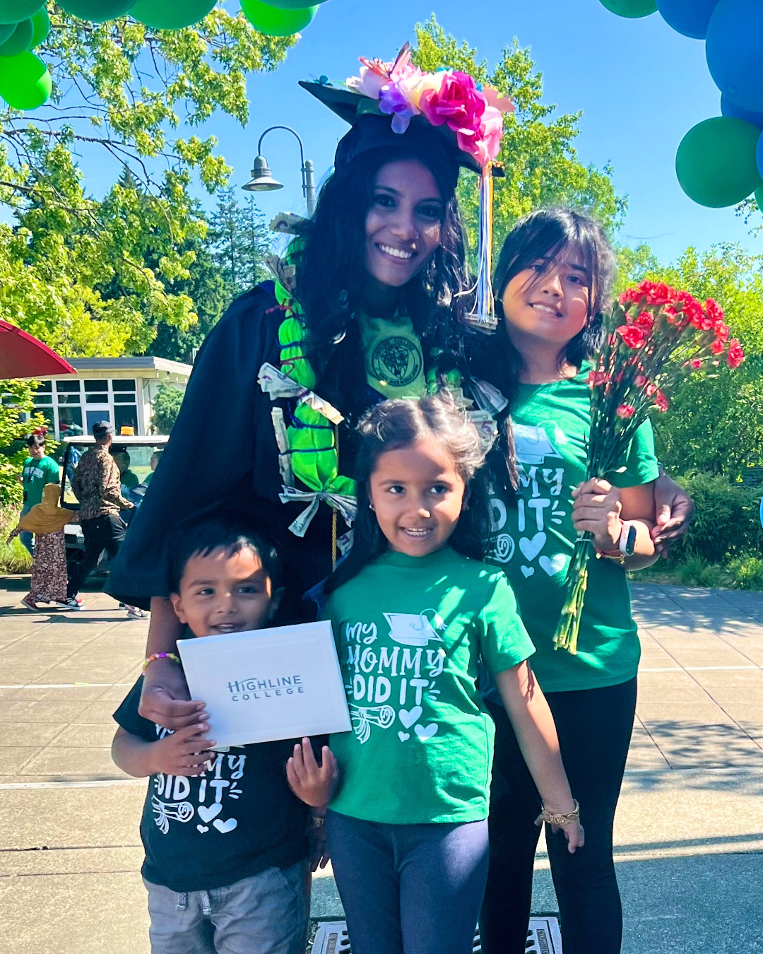 Last Mile awardee Nikrita in a decorated cap with three children in shirts that read "My Mommy Did It"