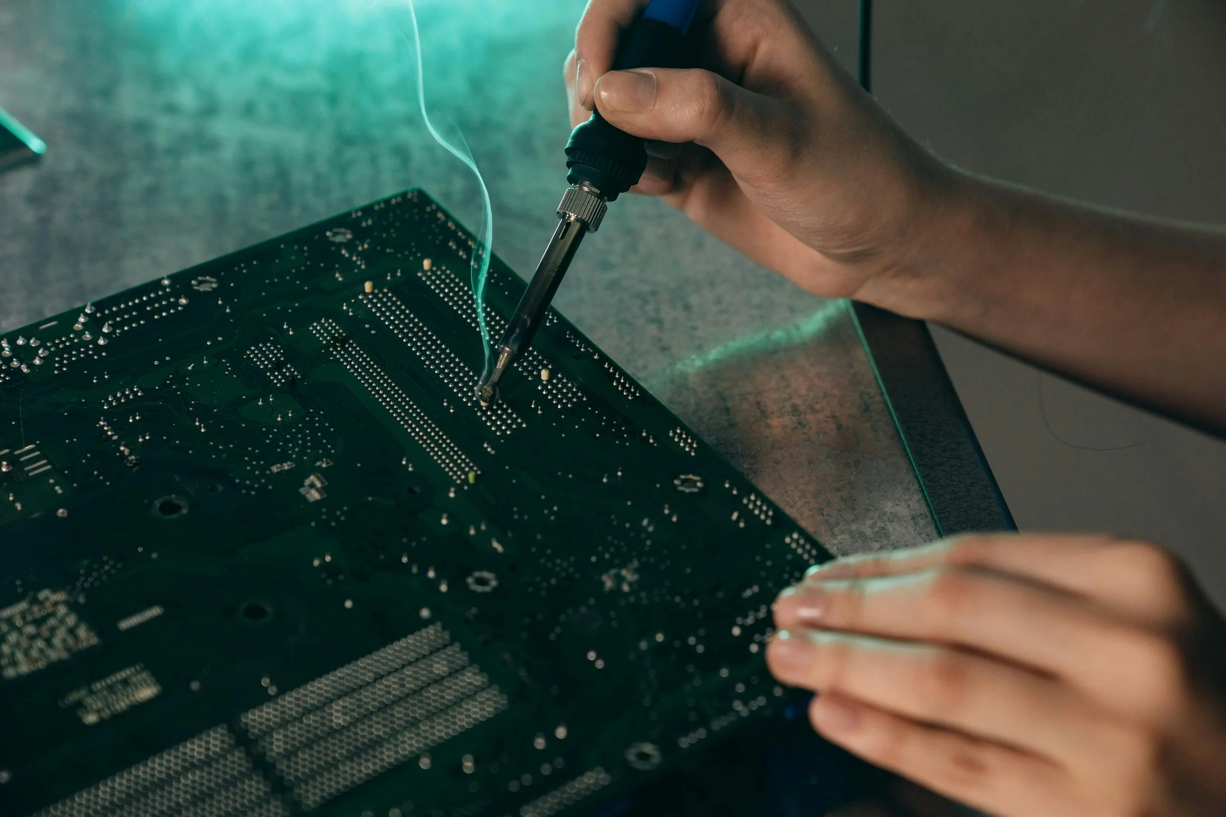 Hands soldering a circuit board
