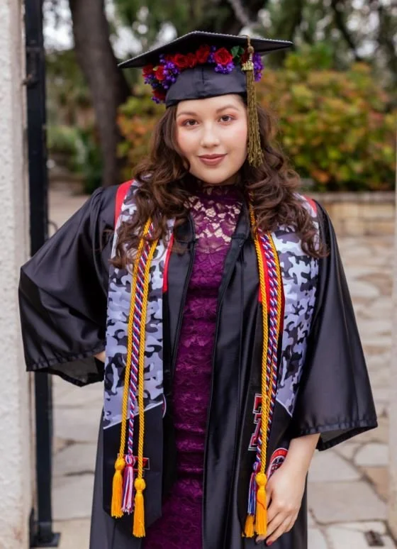 Last Mile awardee Gentle R. in a decorated cap and gown with honor cords