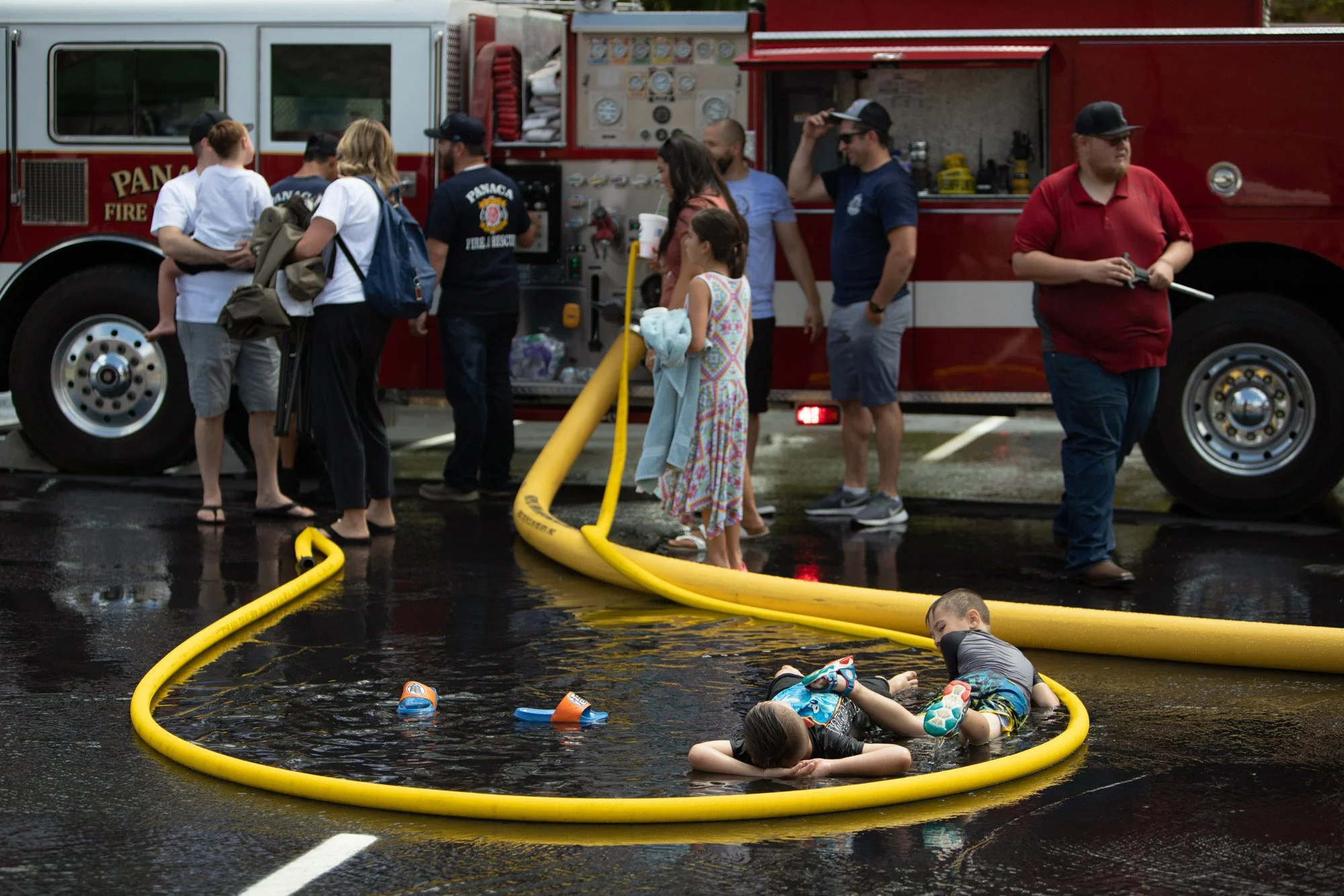 Boys relax in a fire hose pool after the Money Scramble on Saturday, July 23.2022, in the Lincoln County High School parking lot in Panaca, Nevada. | Leslie Ostronic