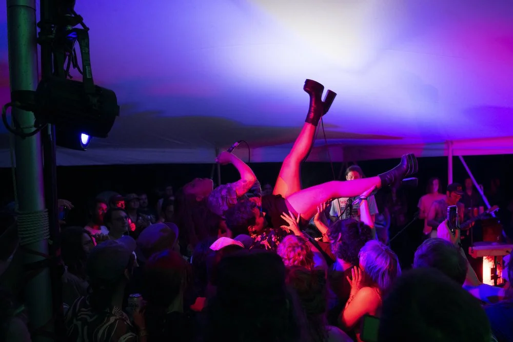 The lead singer of DANA is lifted above the crowd by audience members at an after-hours show during the Nelsonville Music Festival in Nelsonville, Ohio, Saturday, Sept. 3rd, 2022. | Dylan Benedict