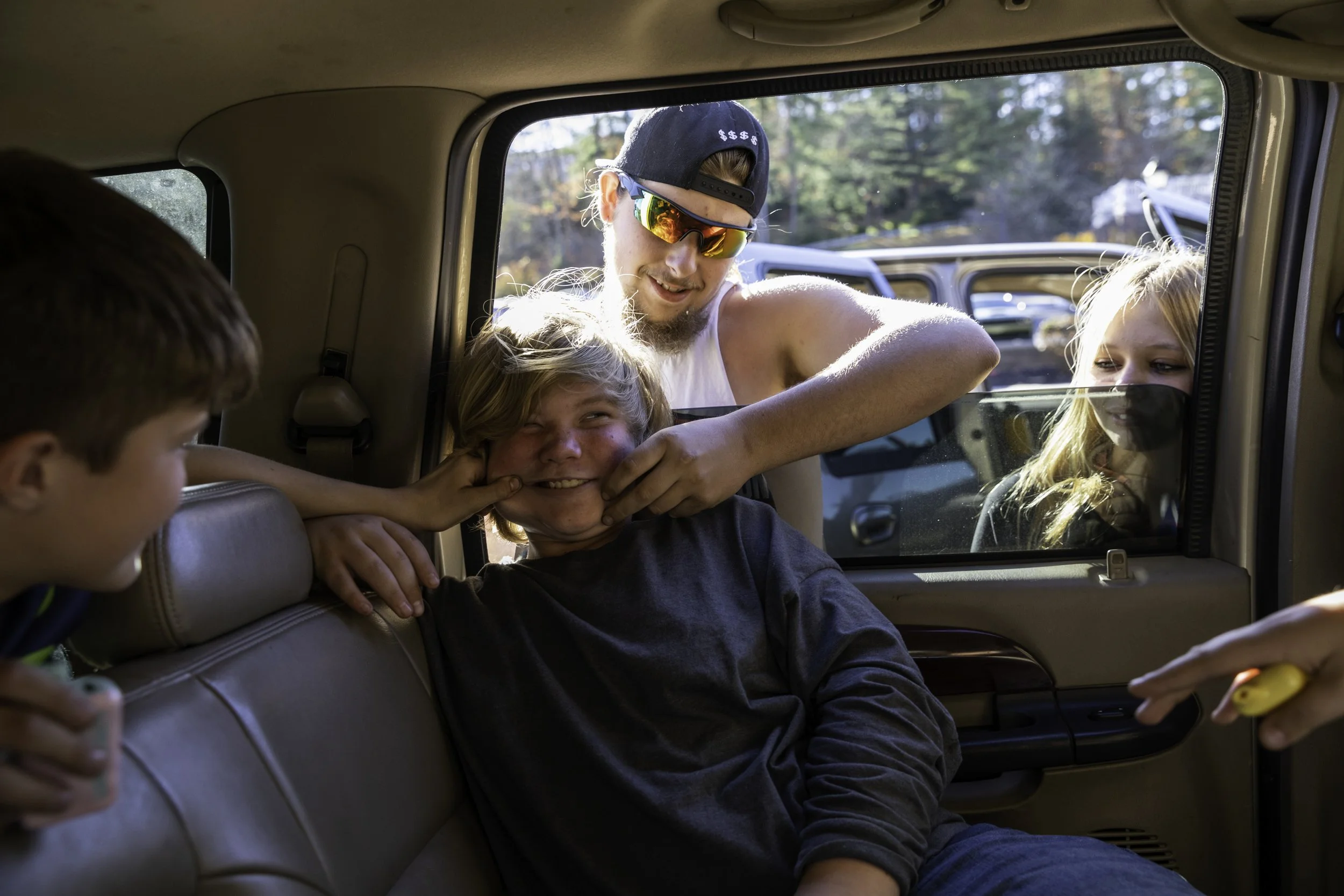 Austin Hagler pinches Jason Grabers face while hanging out in an empty car lot in Athens, OH on October 30, 2022. Seven of us, including myself, rode in an SUV to the New Lexington demolition derby. "We almost died," Jason tells Austin, "The whole tr