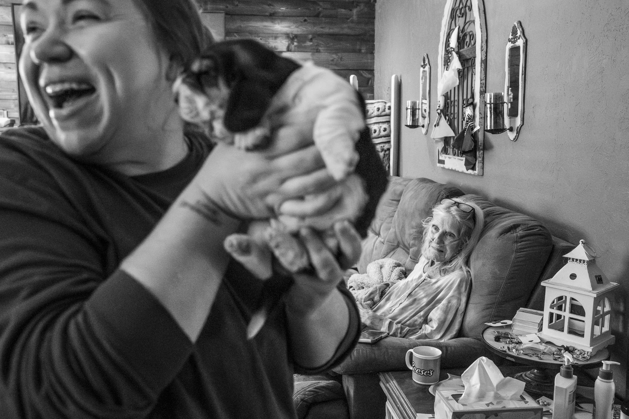 Cassandra Wallin, RN, plays with a puppy in the home of her patient, Mrs. Joy Painter. Cassandra brings levity with her as she visits her patients. "I try to be sunshine in their lives." Cassandra says. "You never know who needs it the most." | Hanna