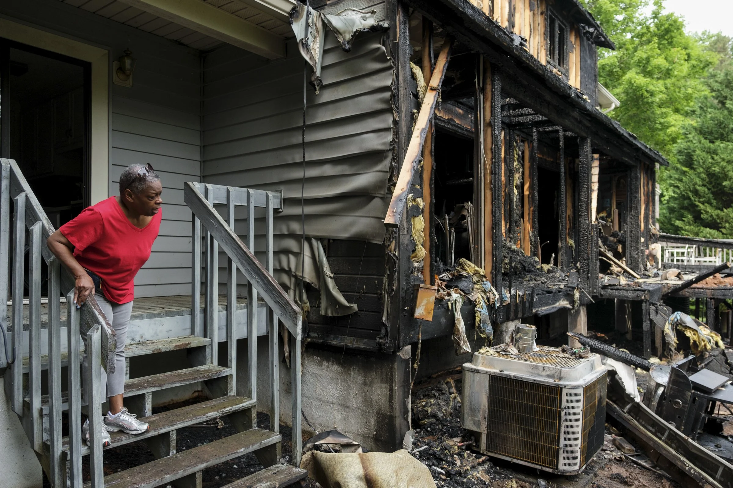 Barbara Steele looks at the damage done to a group of townhouses by a fire the night before in Winston-Salem, N.C., on May 23, 2023. Steele, the president of the HOA, was close with Paul Rutledge, who died in the fire. "He was a good neighbor," Steel
