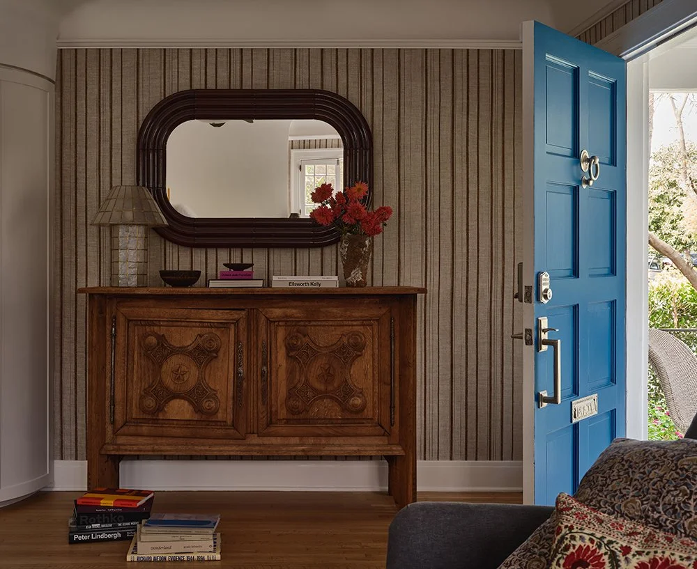 Entryway with blue front door and antique wood console table in a Larchmont Village home designed by Raychel Wade Design