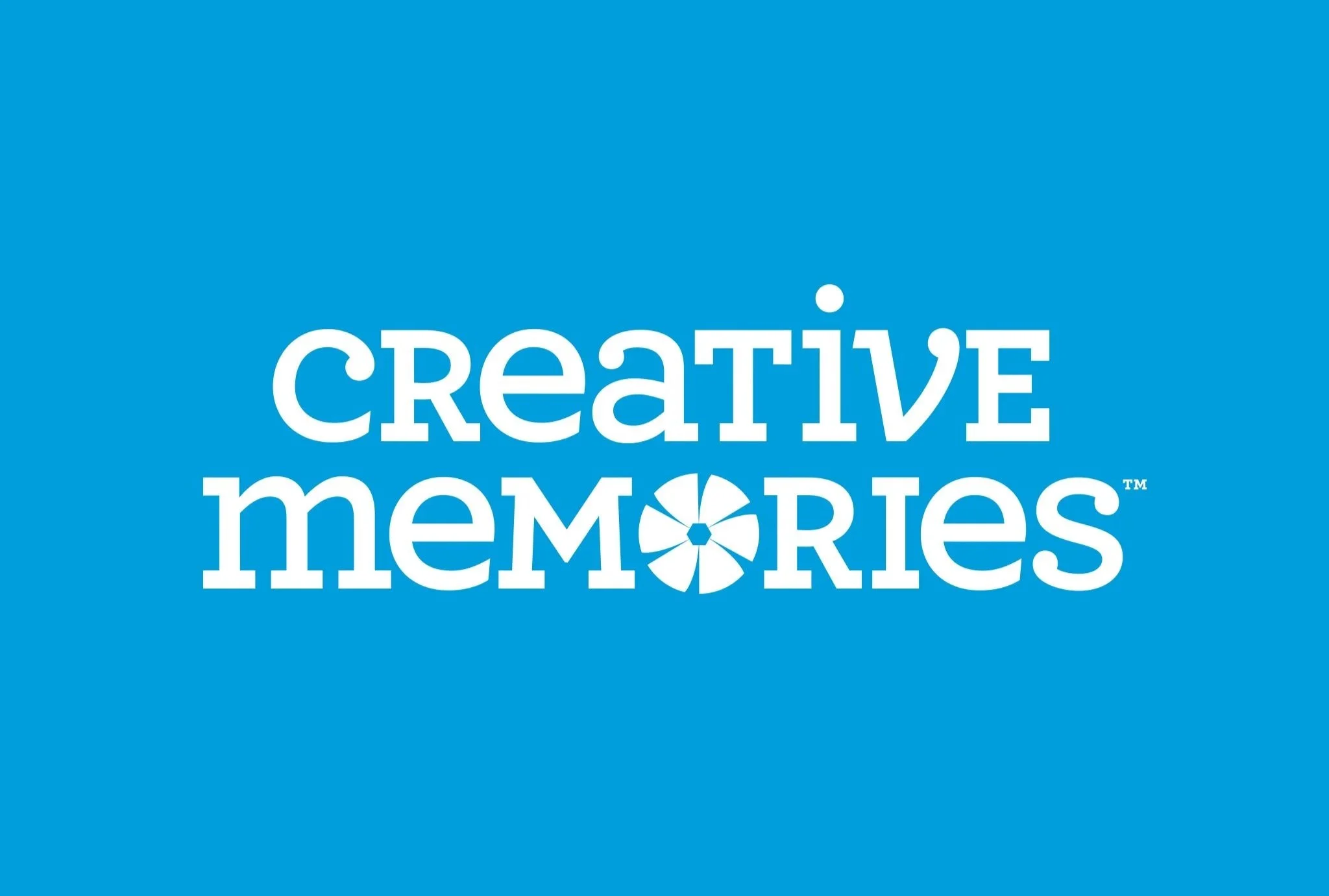 Blue background with the words "CREATIVE MEMORIES" in white, with a stylized flower in place of the "O" in "MEMORIES".