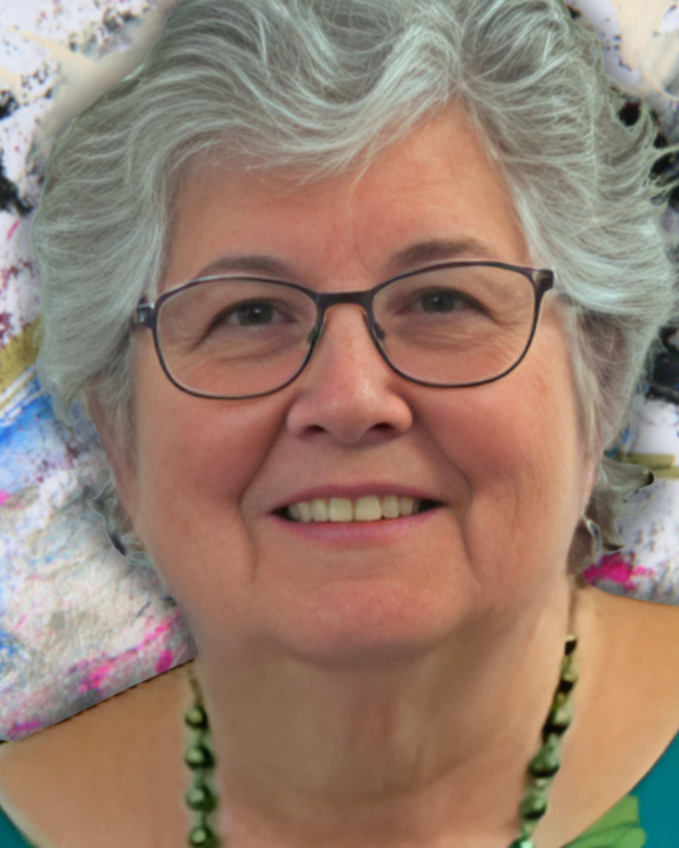 Close-up portrait of a middle-aged woman with short gray hair, wearing glasses, smiling, and posing against a colorful abstract background.