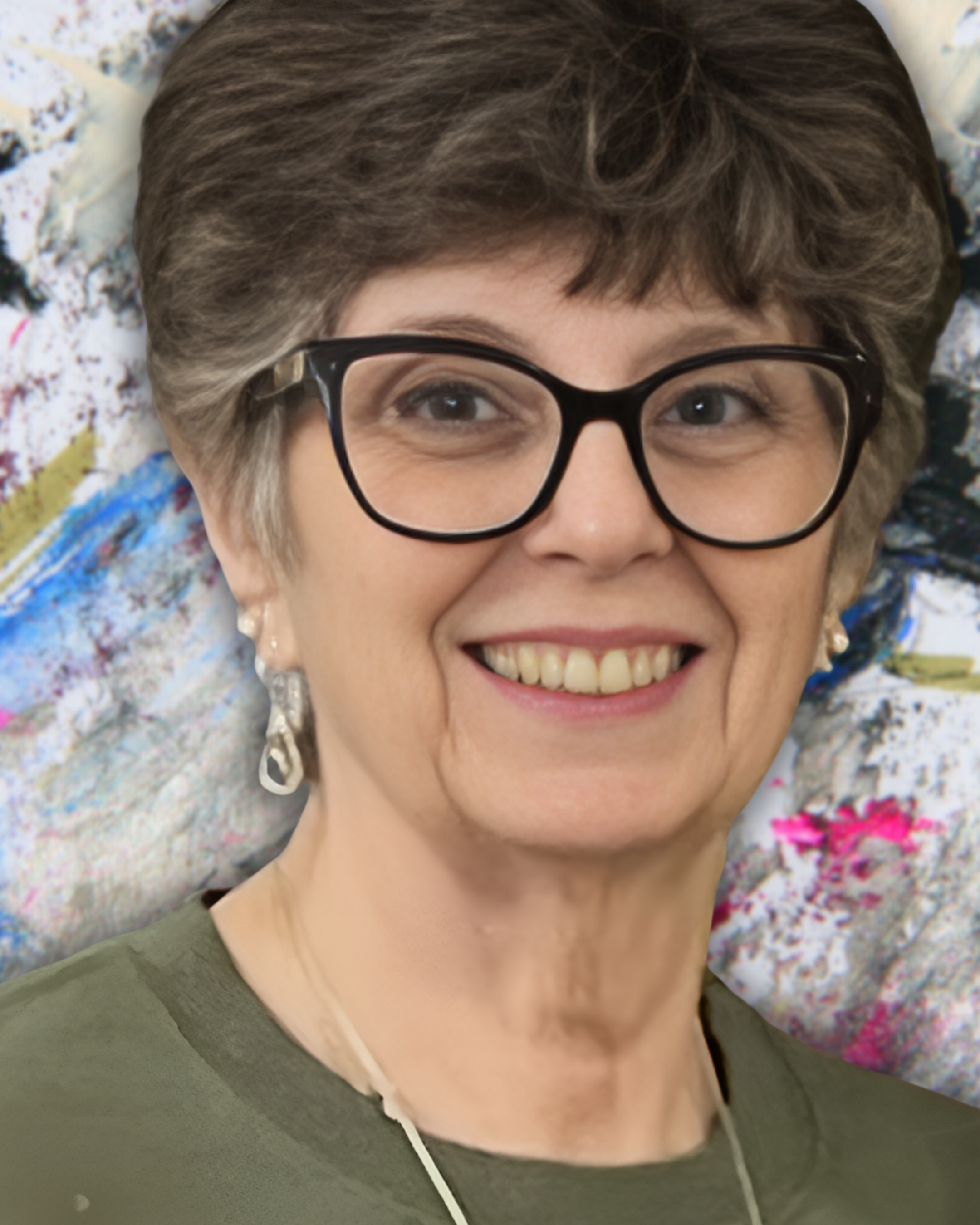 A woman with short, gray hair wearing glasses, smiling, with colorful abstract art in the background.