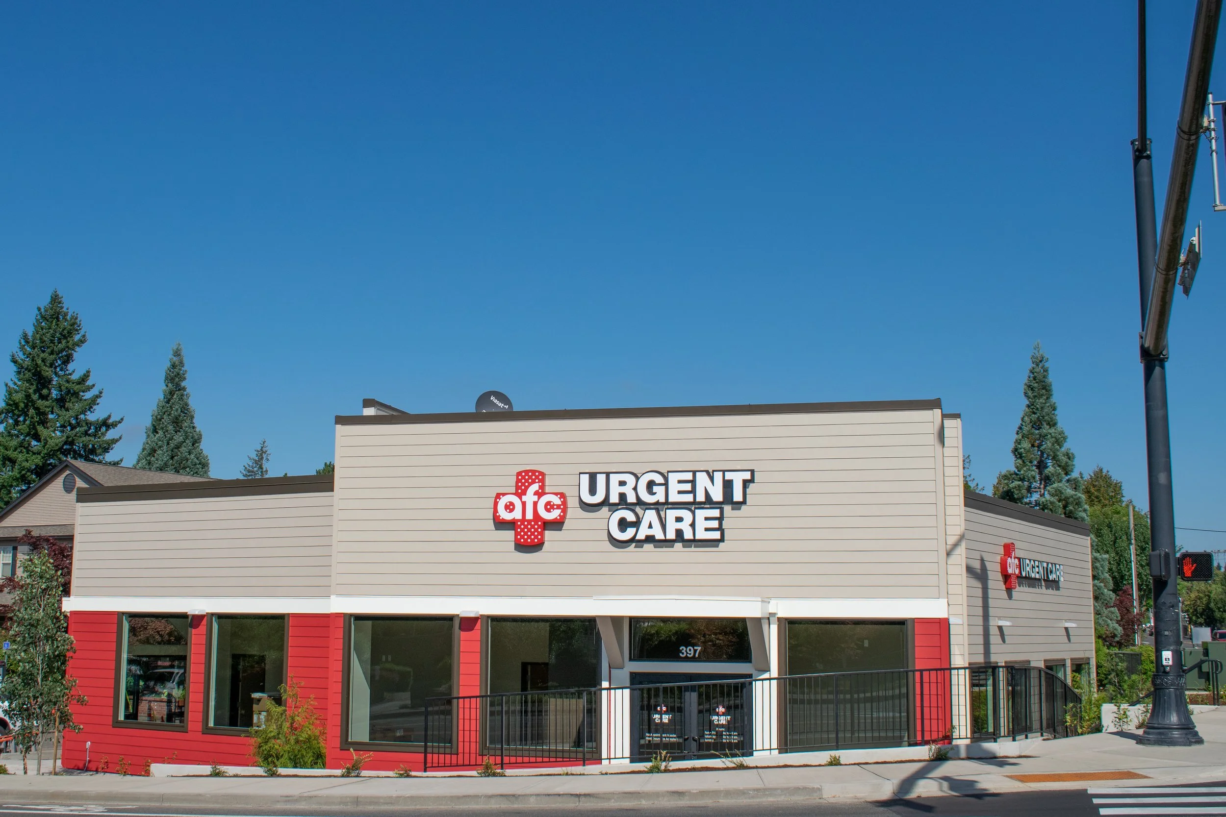 A beige and red medical clinic building with a sign reading 'AFC URGENT CARE' under a clear blue sky.