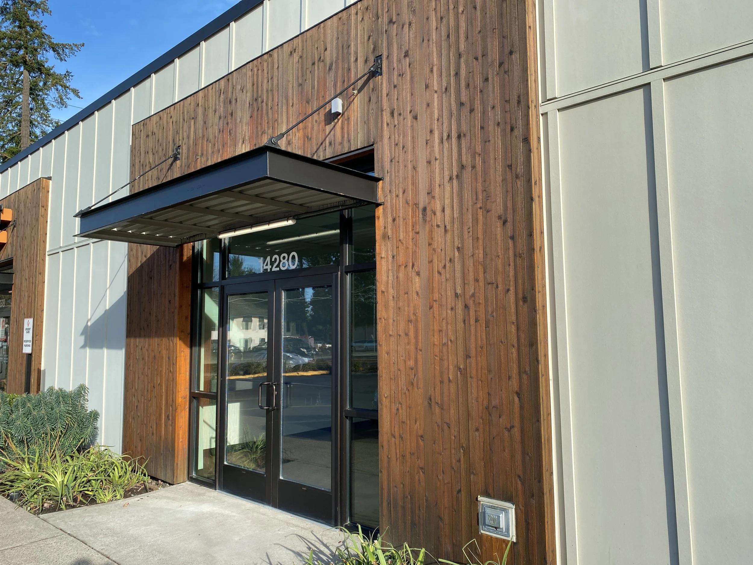 Exterior of a modern building with a glass door and wooden paneling, displaying the number 14280.