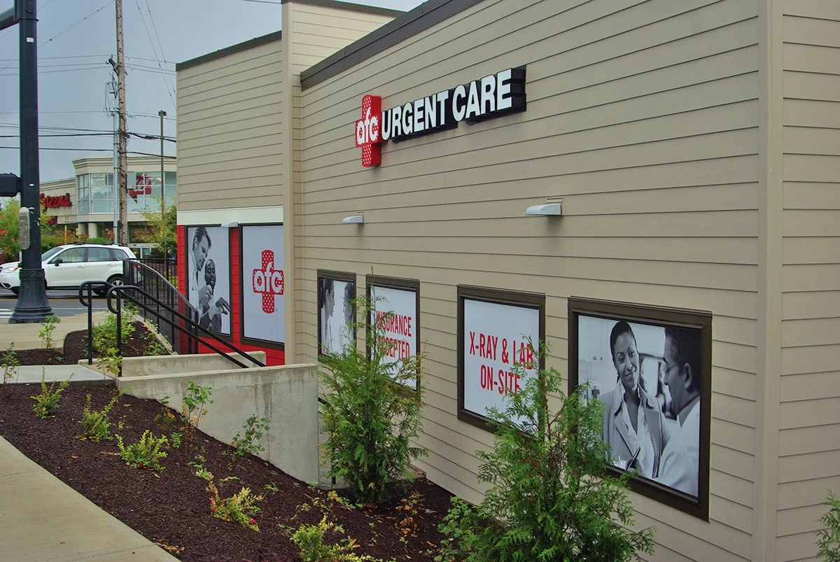 Exterior of an AFC Urgent Care building with windows displaying signs and black-and-white images of medical professionals and patients.