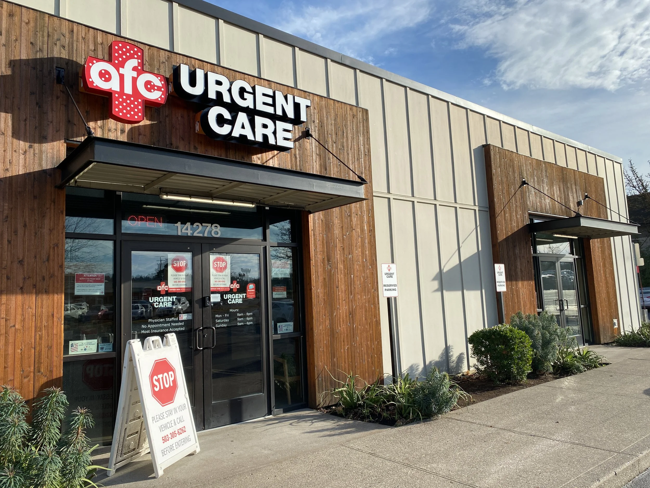 Exterior of an urgent care clinic with wooden accents and modern design, featuring signage for 'aFC URGENT CARE' and a parking area with reserved signs.